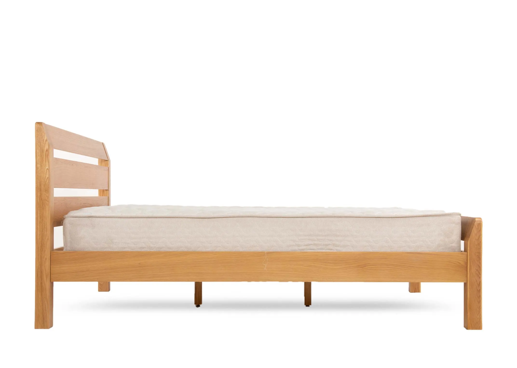 A double 4ft6 oak bed frame from EZ Livings Iris range. Front view of the bed chunky feet