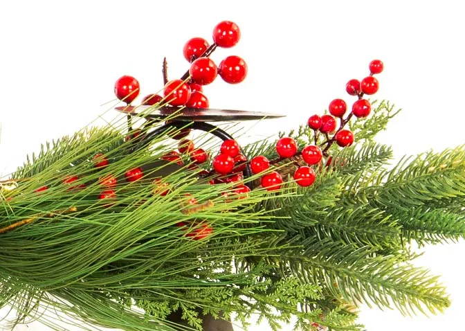 A berry & pine cone garland covered candle holder from EZ Livings Christmas range. Closeup of berries