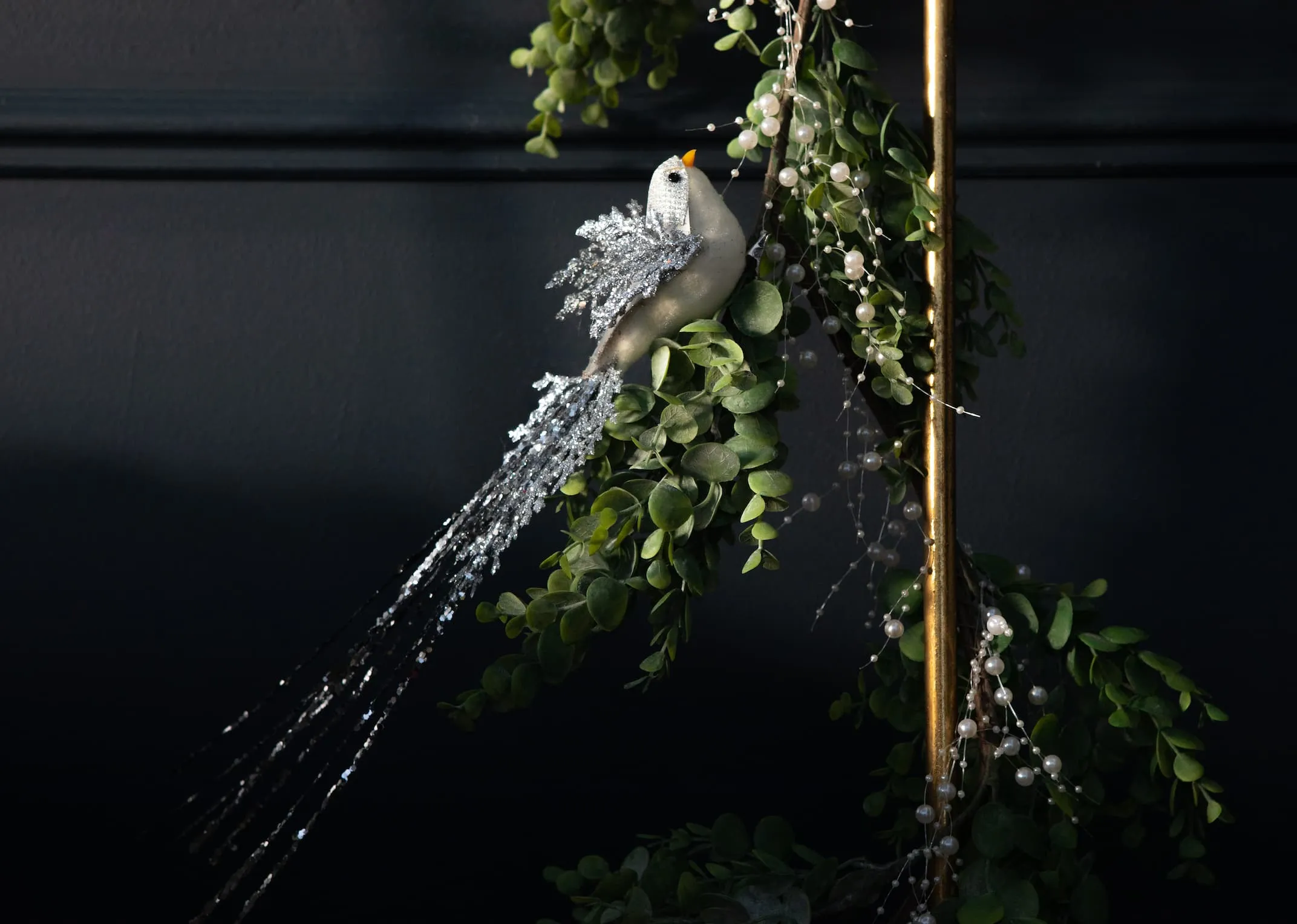 A lifestyle image of the Silver Glitter clip on bird with snow garland