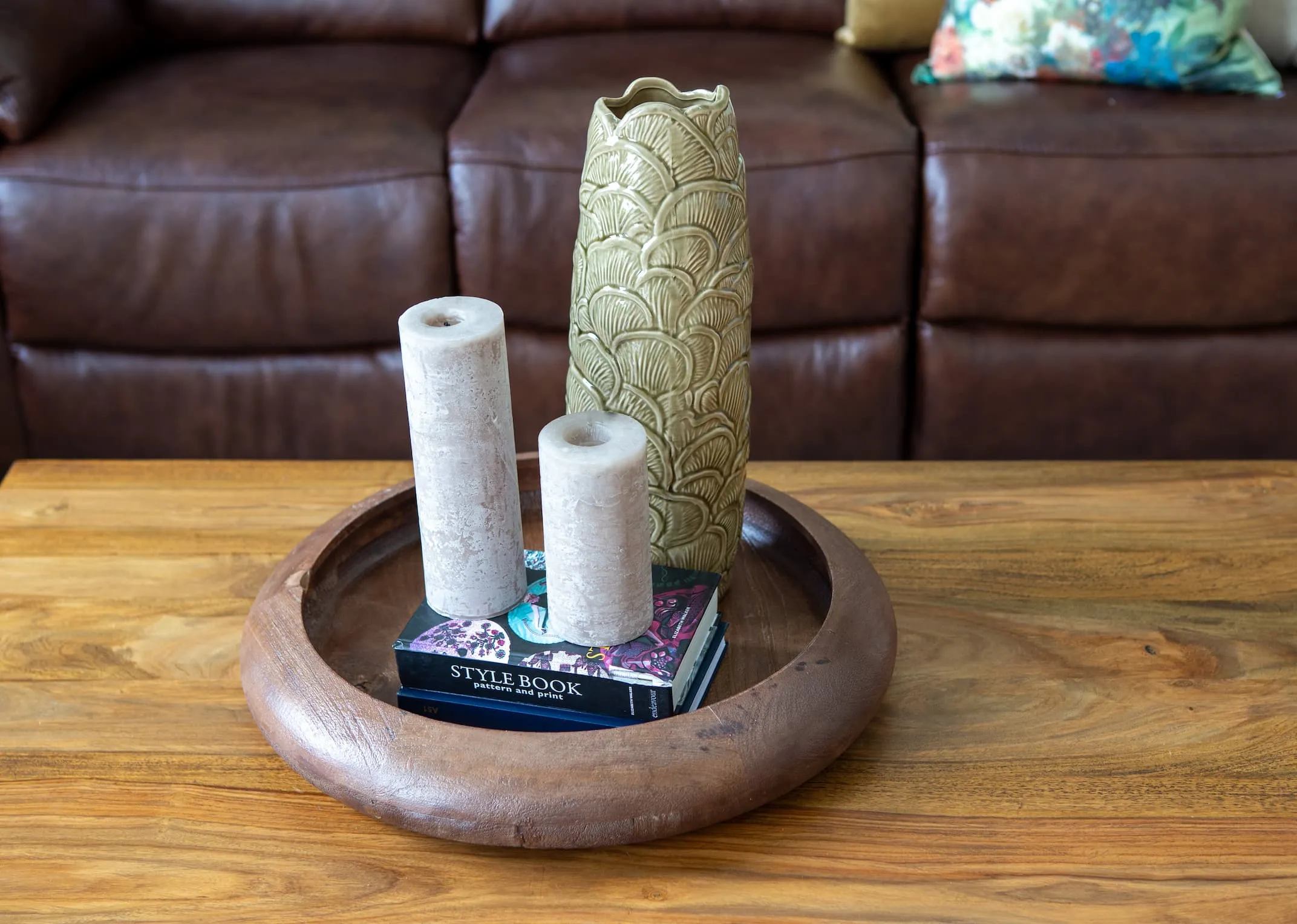 A lifestyle image of the Osida Dish with Travis vase and 2 candles on the India coffee table.