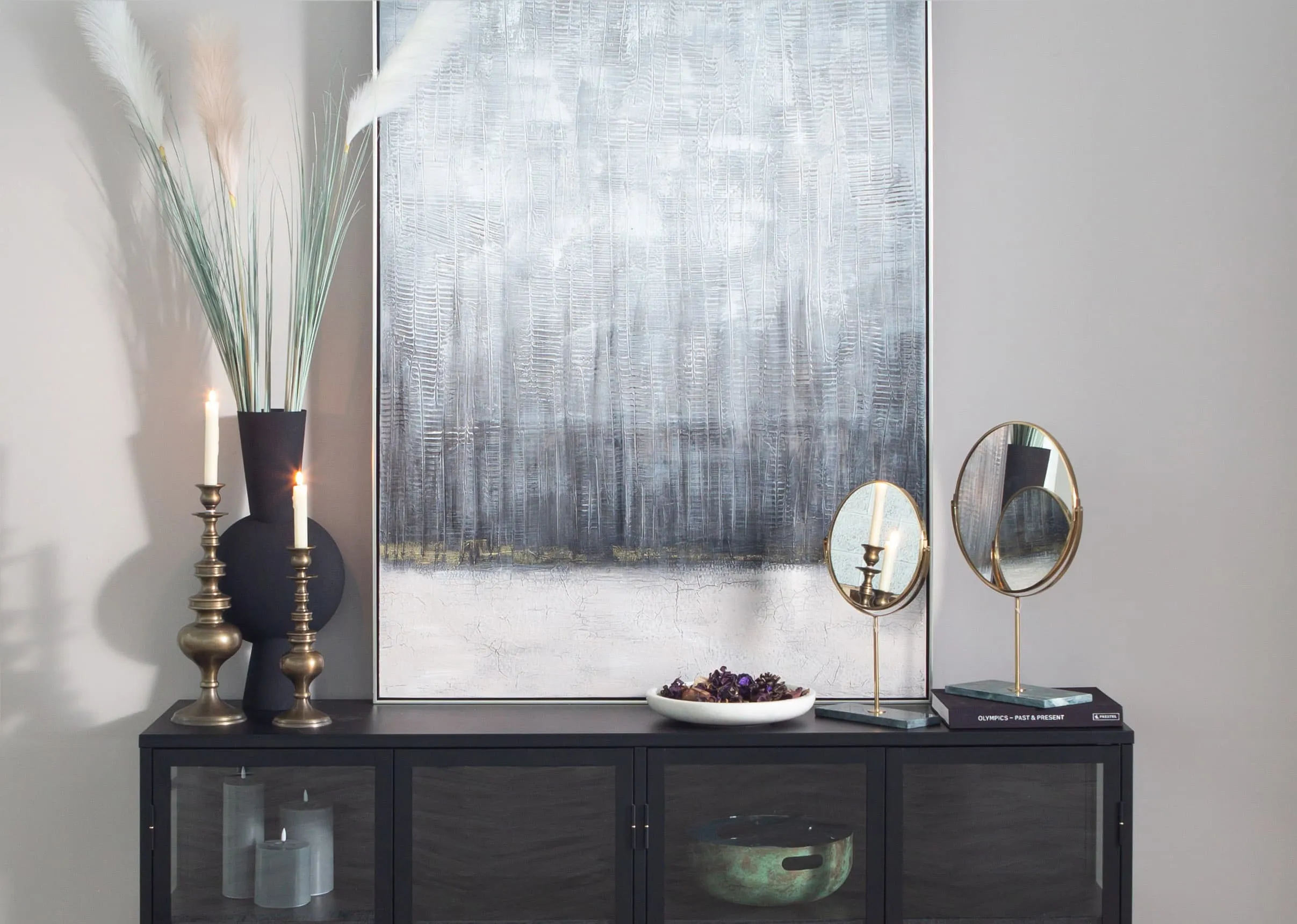 A lifestyle image of the Riesco Table mirror with Lizet candlesticks and Kavandu vase