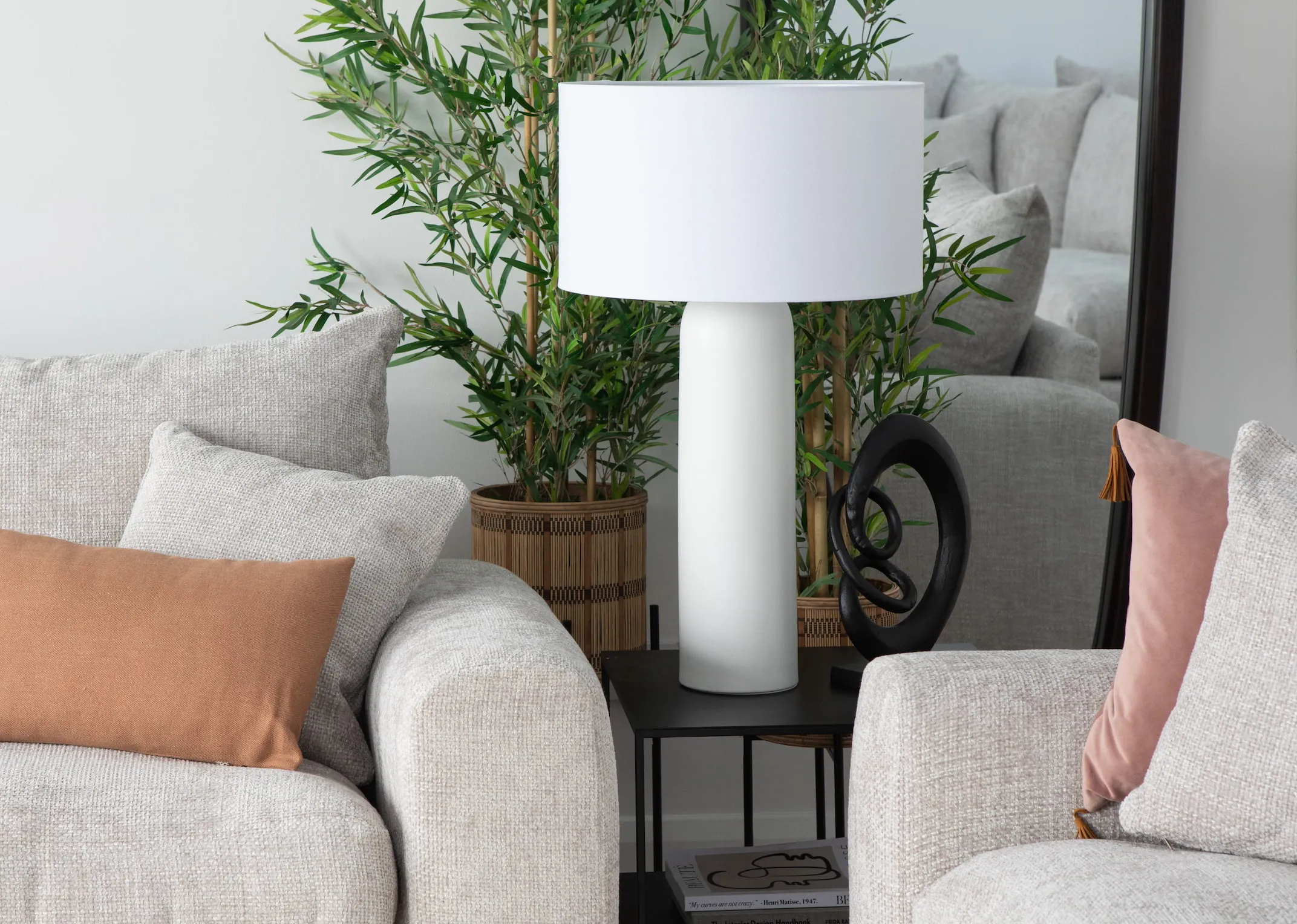 A lifestyle image of the Saturn table lamp on a pebble side table with Aurora sofa