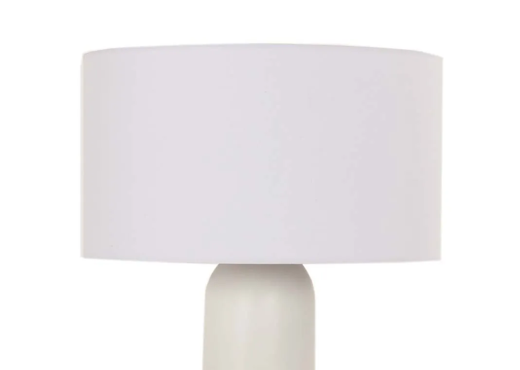 A lifestyle image of the Saturn table lamp on a pebble side table with Aurora sofa