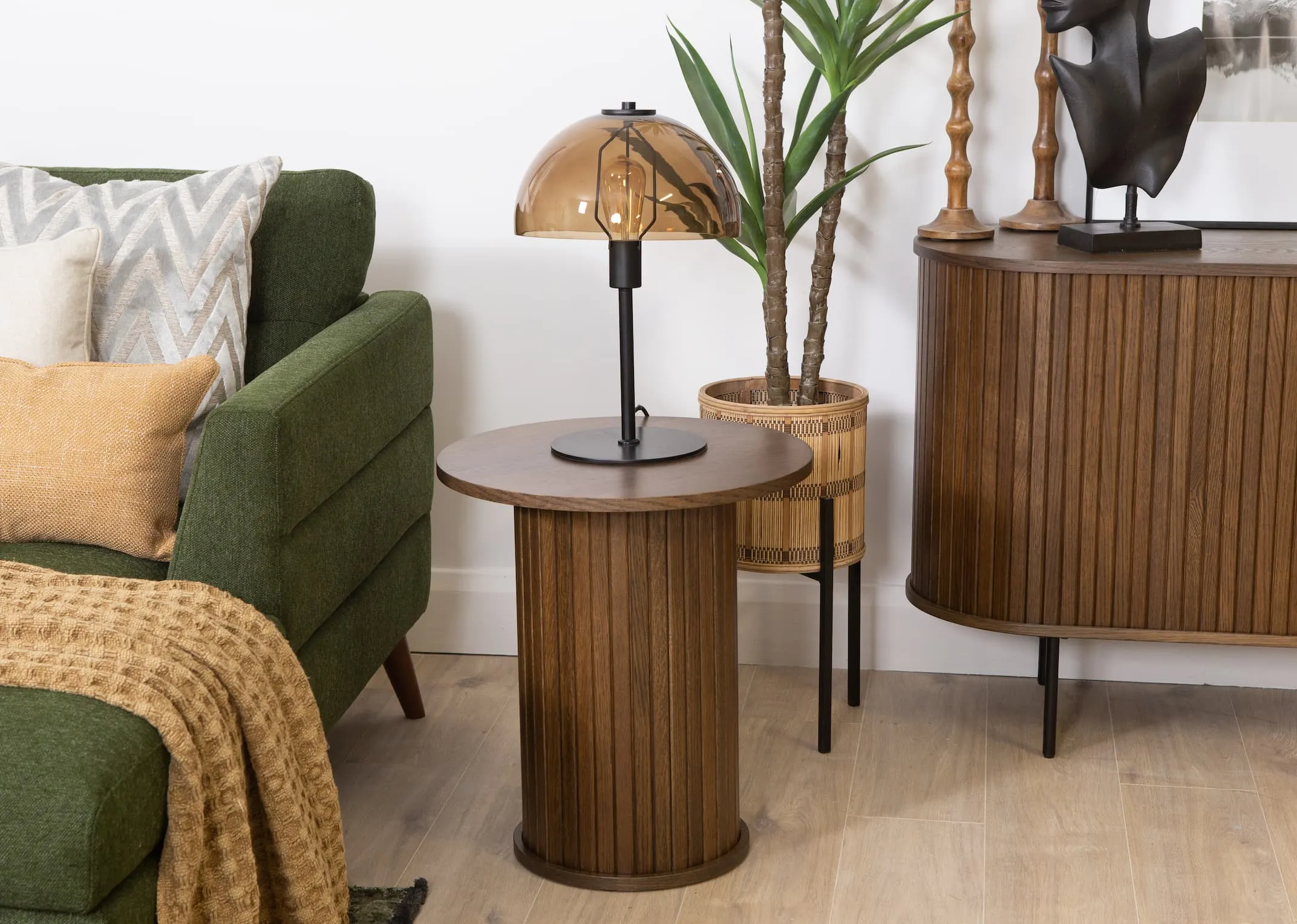 A lifestyle image of the Nola smoked oak lamp table with Mellan table lamp and Presley corner sofa