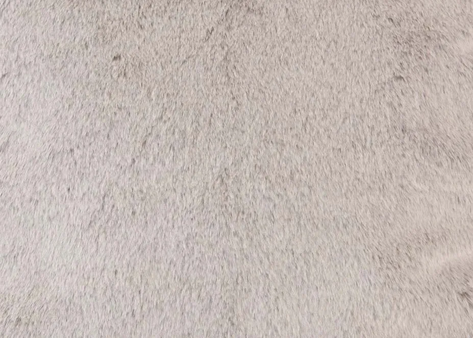 A lifestyle image of the Tabitha Snuggler with Tipped silver cushion and matching throw with Monrie side table.