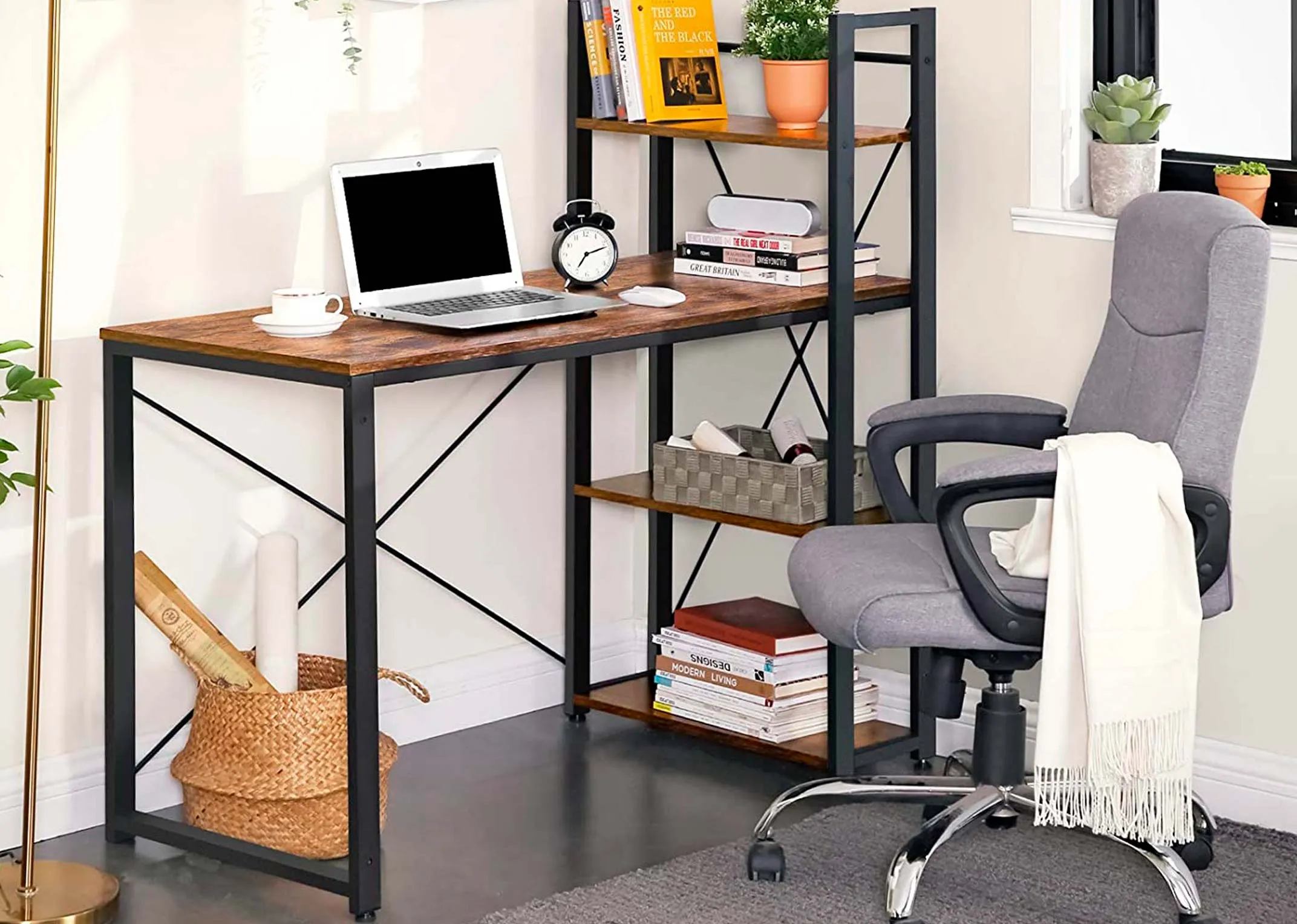 A lifestyle image of the Cero Computer desk in an office environment paired with grey swivel chair & shelves full of plants