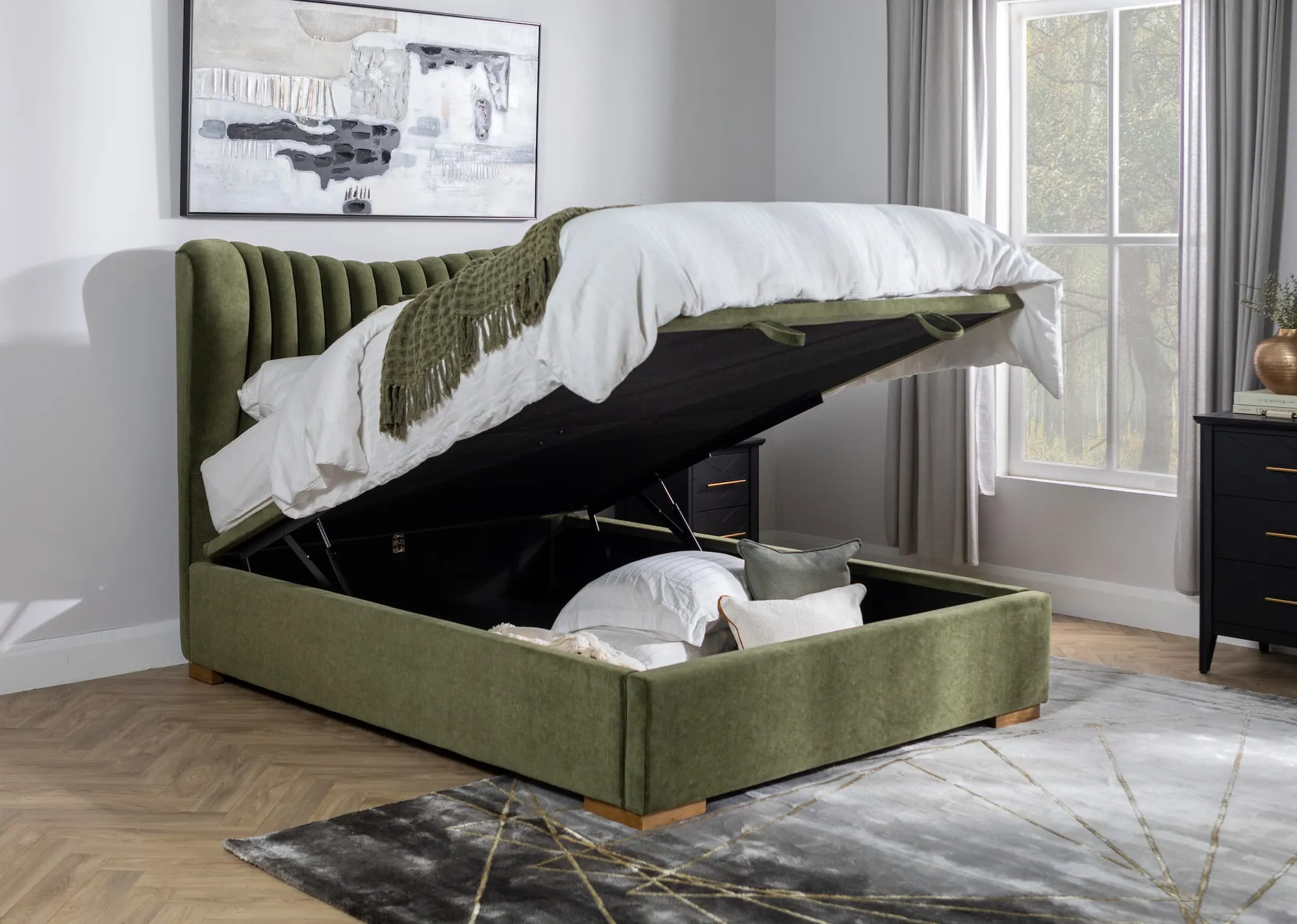 A lifestyle image of the Robin velvet ottoman bed open to reveal storage space with Avery rug.