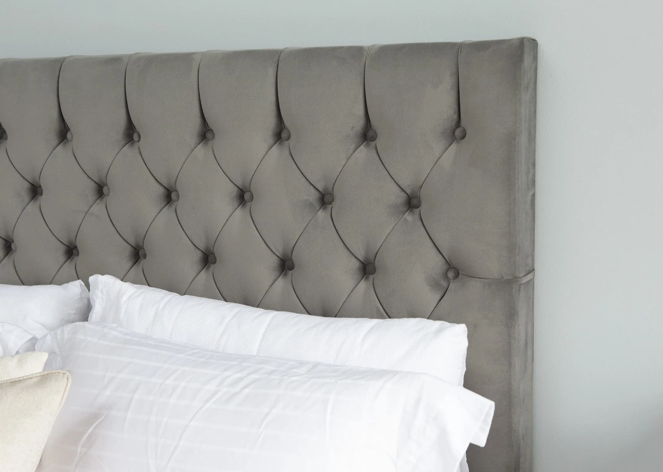 A lifetsyle image of the Palermo headboard in Plush velvet asphaly upholstery with tufted button detail.