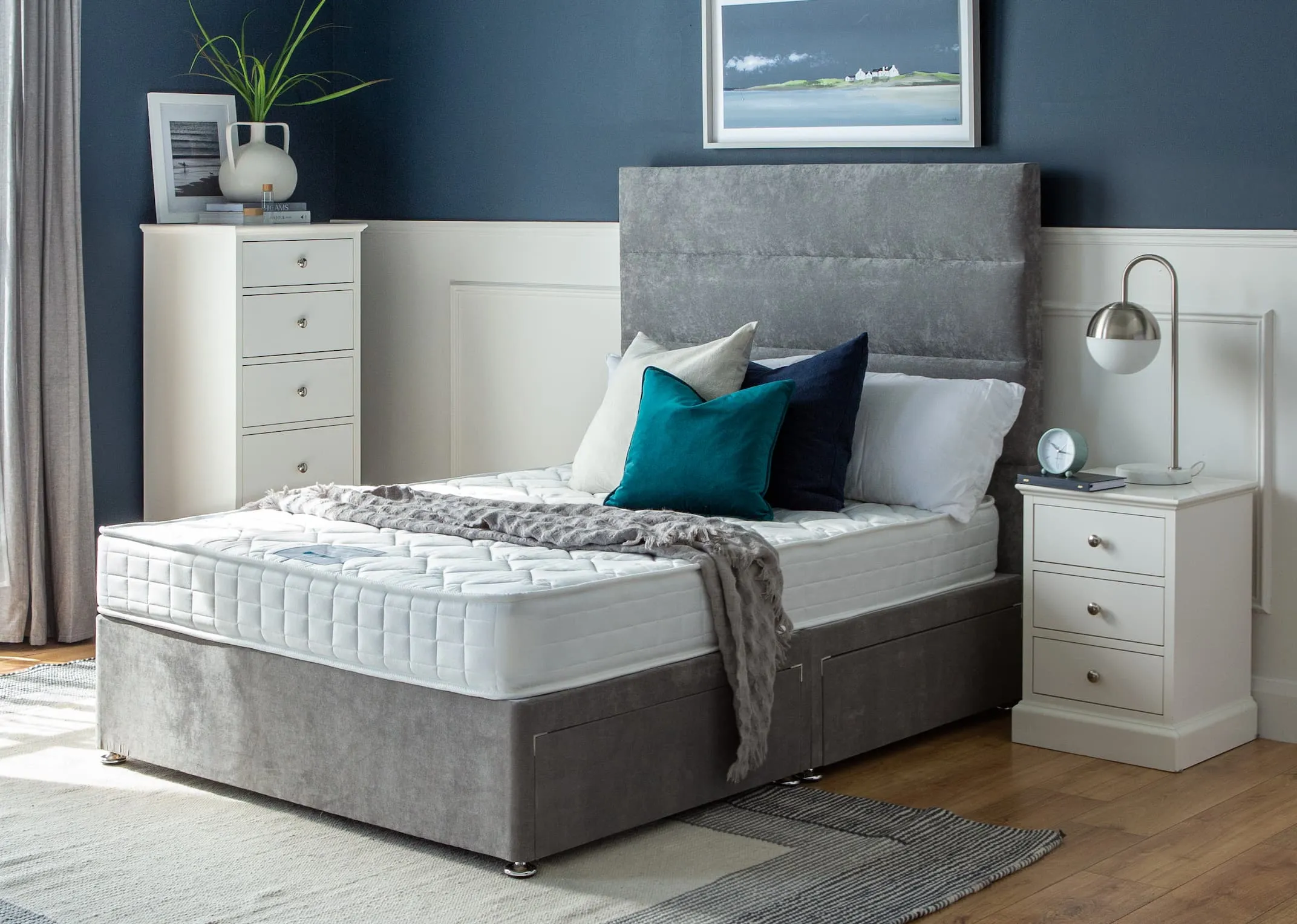 A lifestyle image of the Florence Bed base with mattress and side locker and tallboy.