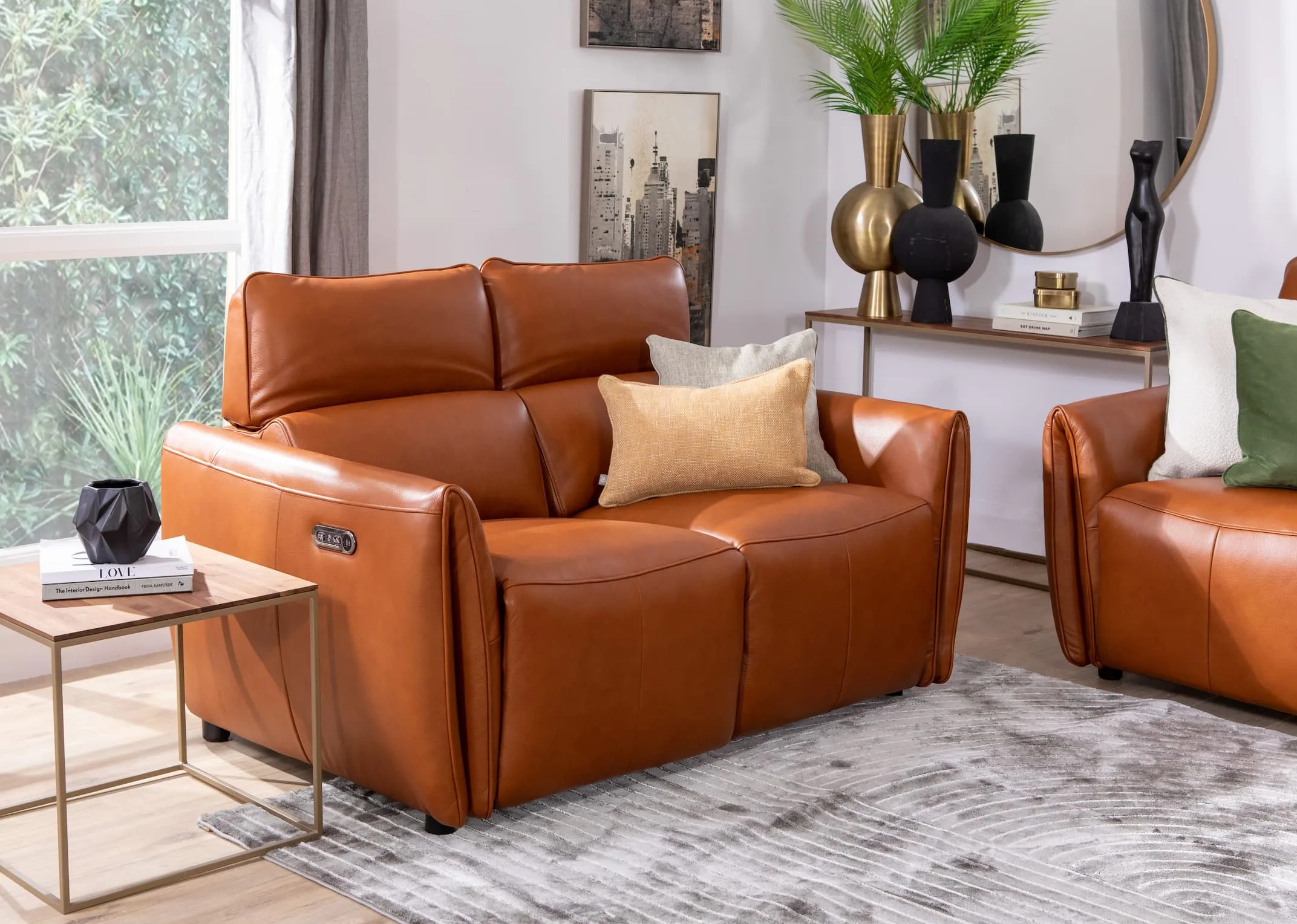 A lifestyle image of the Icon 2 seater sofa with frida rug and aston walnut tables