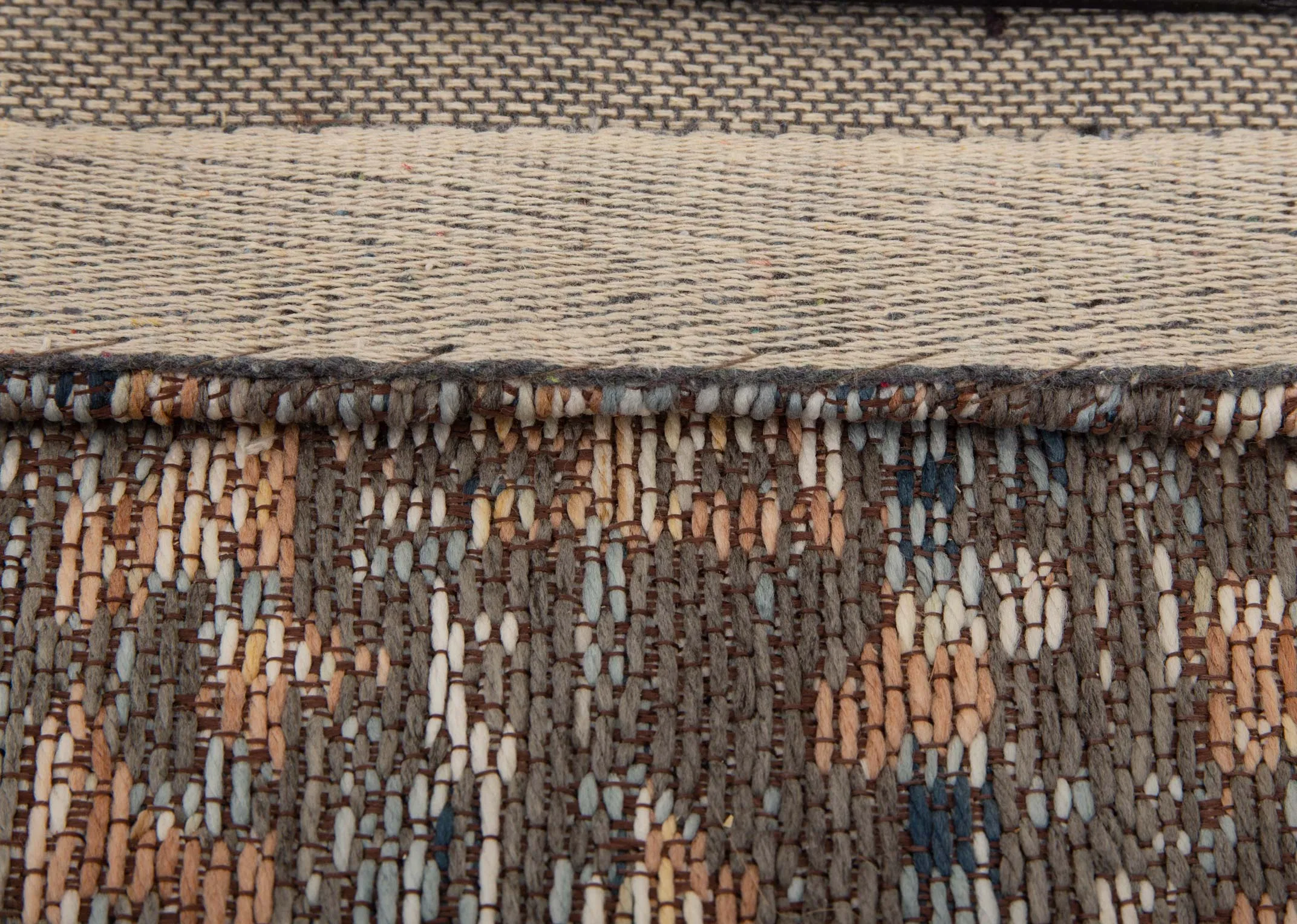 A rust grey & silver print rug from EZ Livings Maxima range. Closeup of woven fabric & underlay