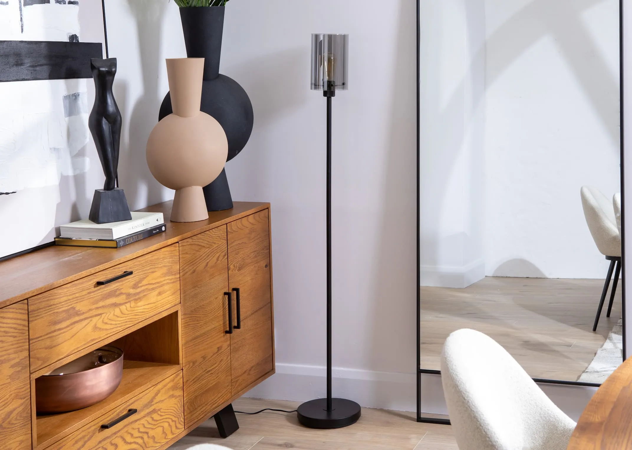 A lifestyle image of the Leanne smoked glass floor lamp with the light off paired with Oslo sideboard.