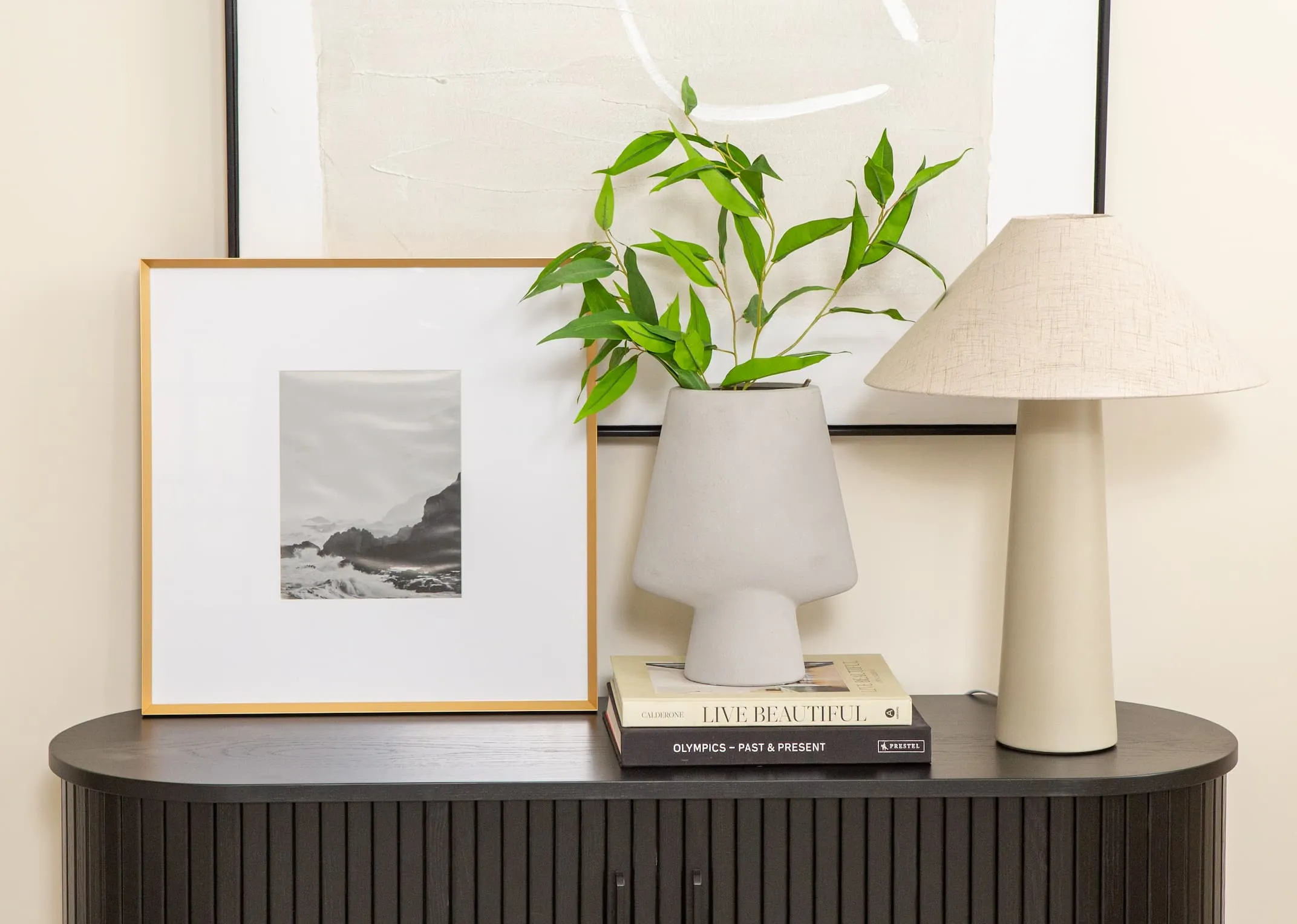 A lifestyle image of the Arabel Medium photo frame with the Nola black tv unit and Daisy table lamp.