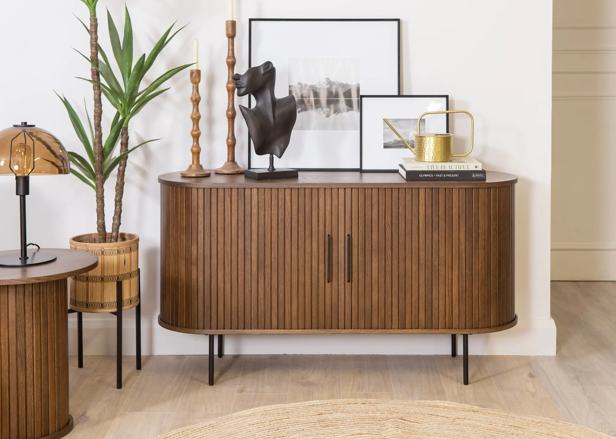 A lifestyle image of the Arabel Black small and large frames on a Nola smoked oak sideboard with Takino candleholders and face bust