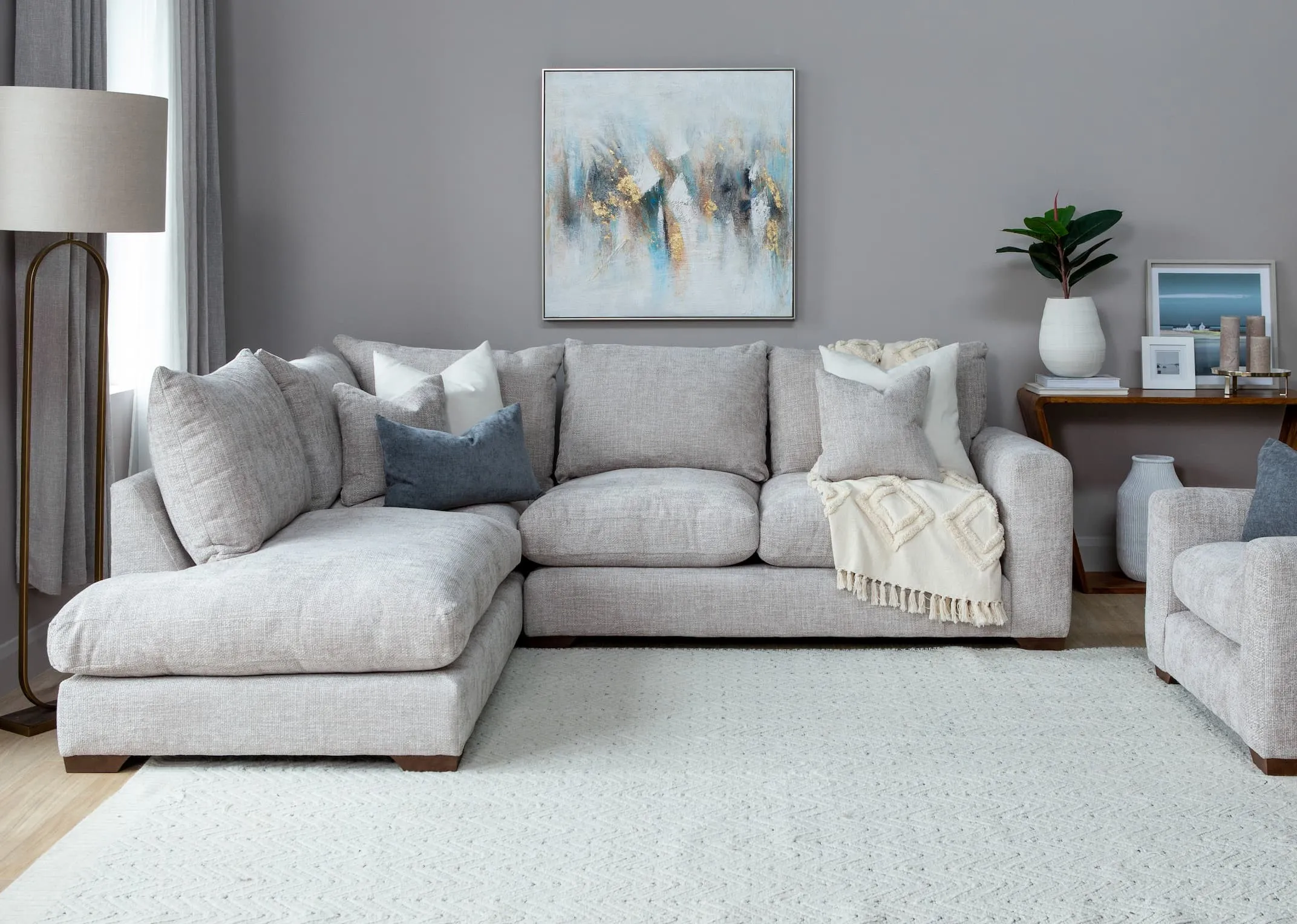 A lifestyle image of the Aurora RHF corner sofa with capri console and abstract canvas