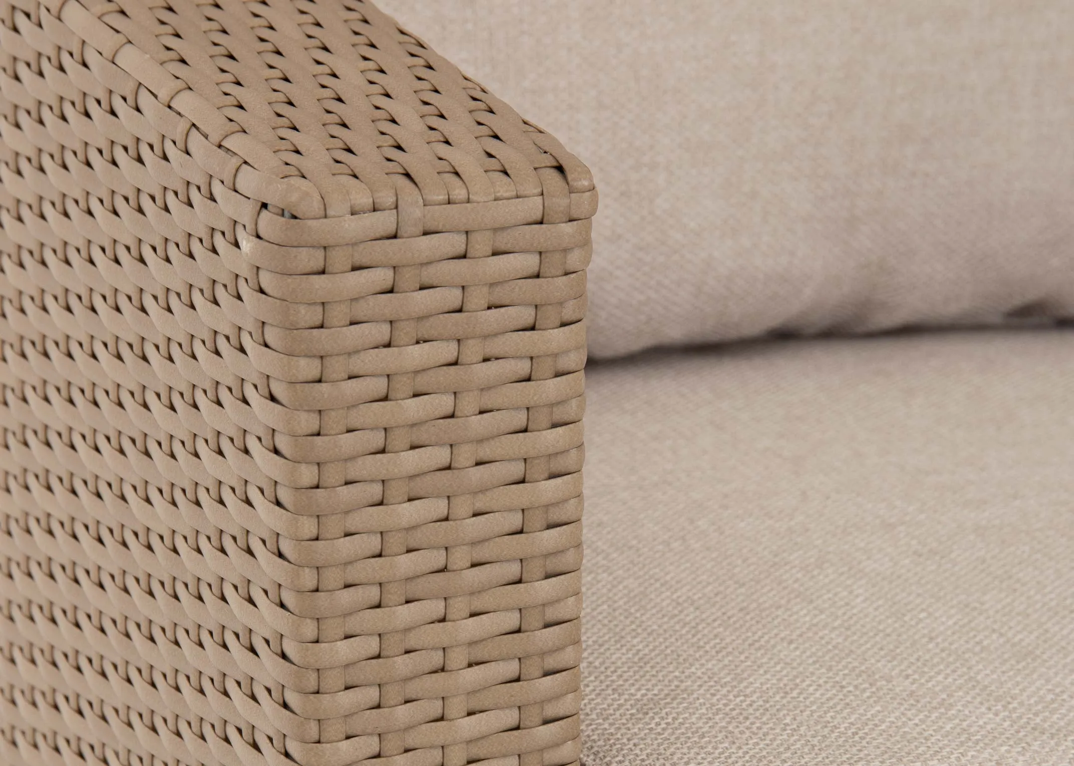 A lifestyle image of the Malaga Corner Garden set with closeup of the rattan on table and stool with 2 lanterns