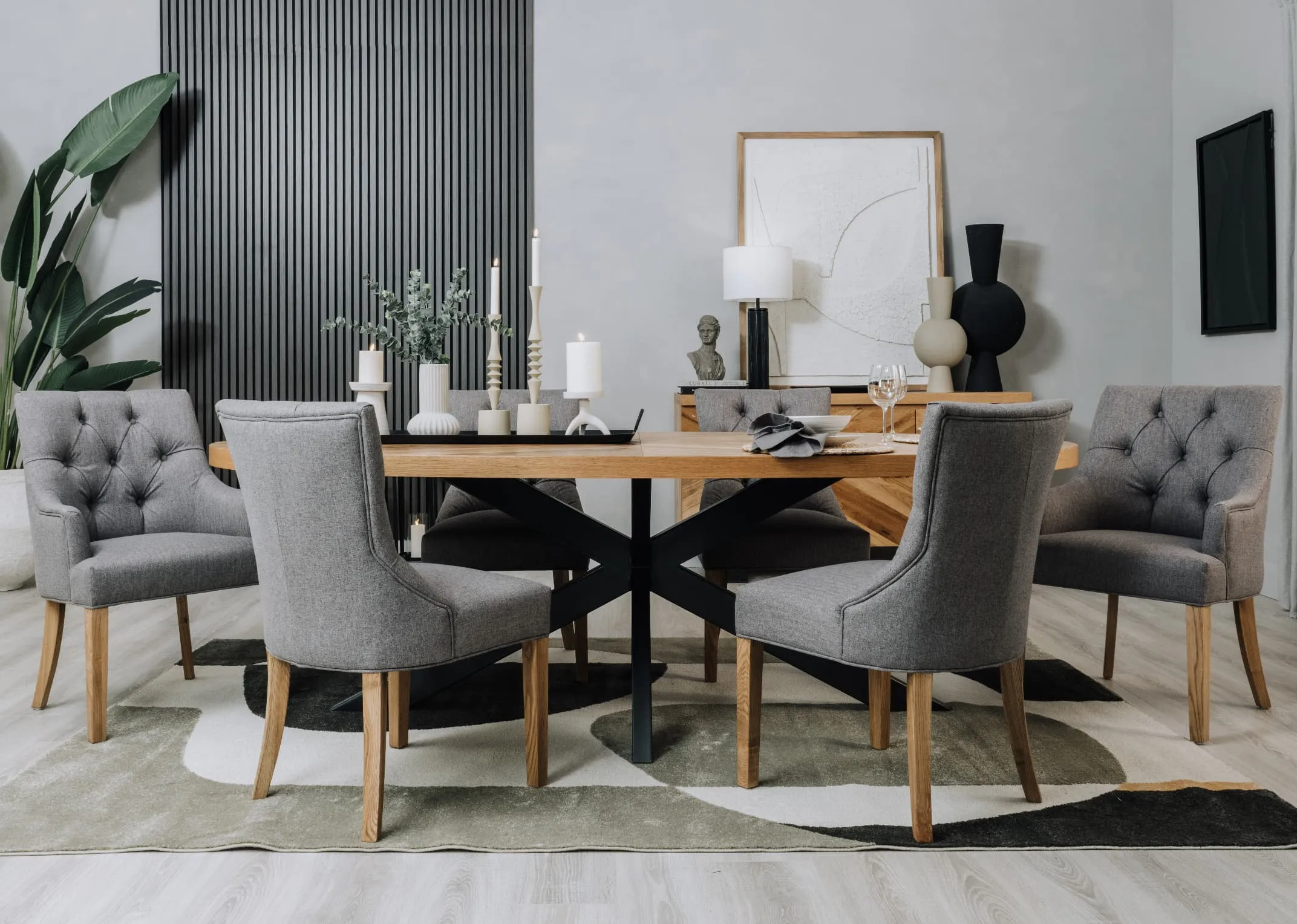 A lifestyle image of the Ellipse oval dining table with Felix grey carver and dining chairs with Bree rug.