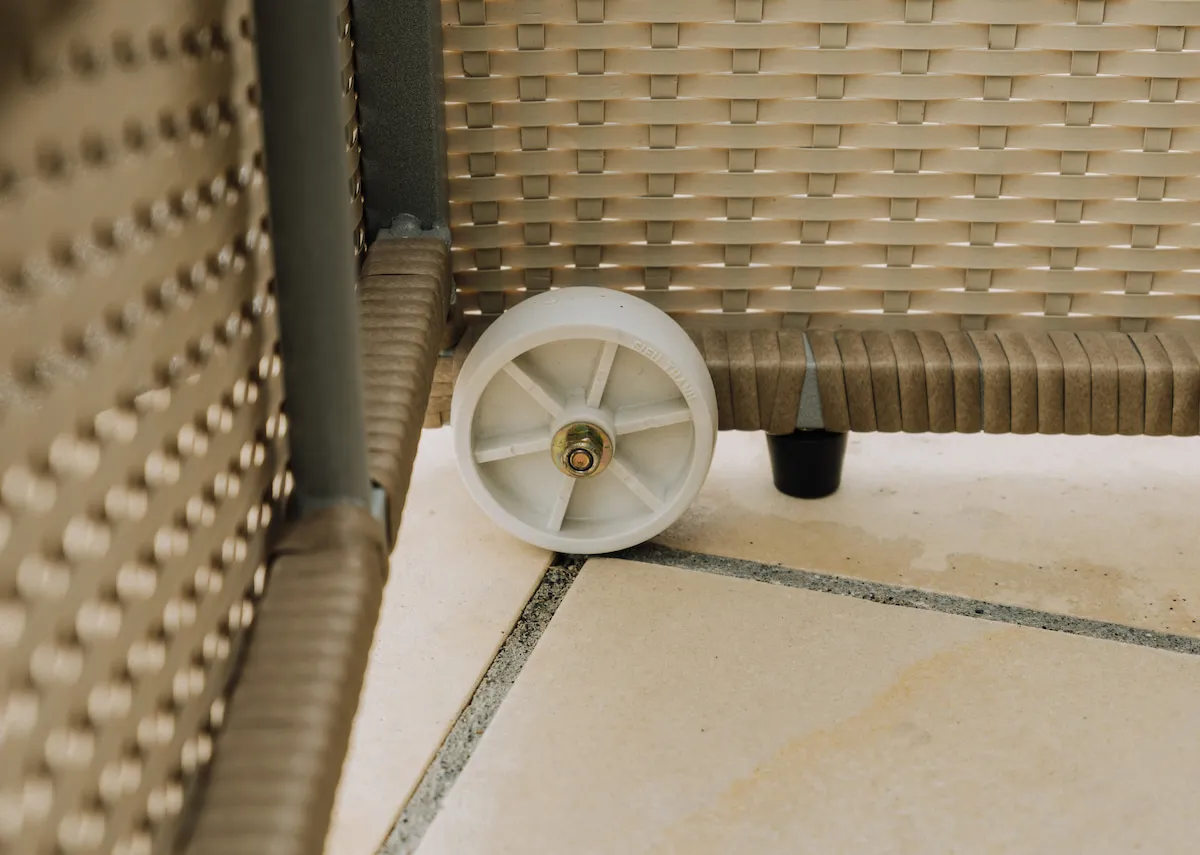 A light brown wicker sunlounger with beige fabric cushion from EZ Livings Granada range. Side view of headrest down with lounger in bed mode.