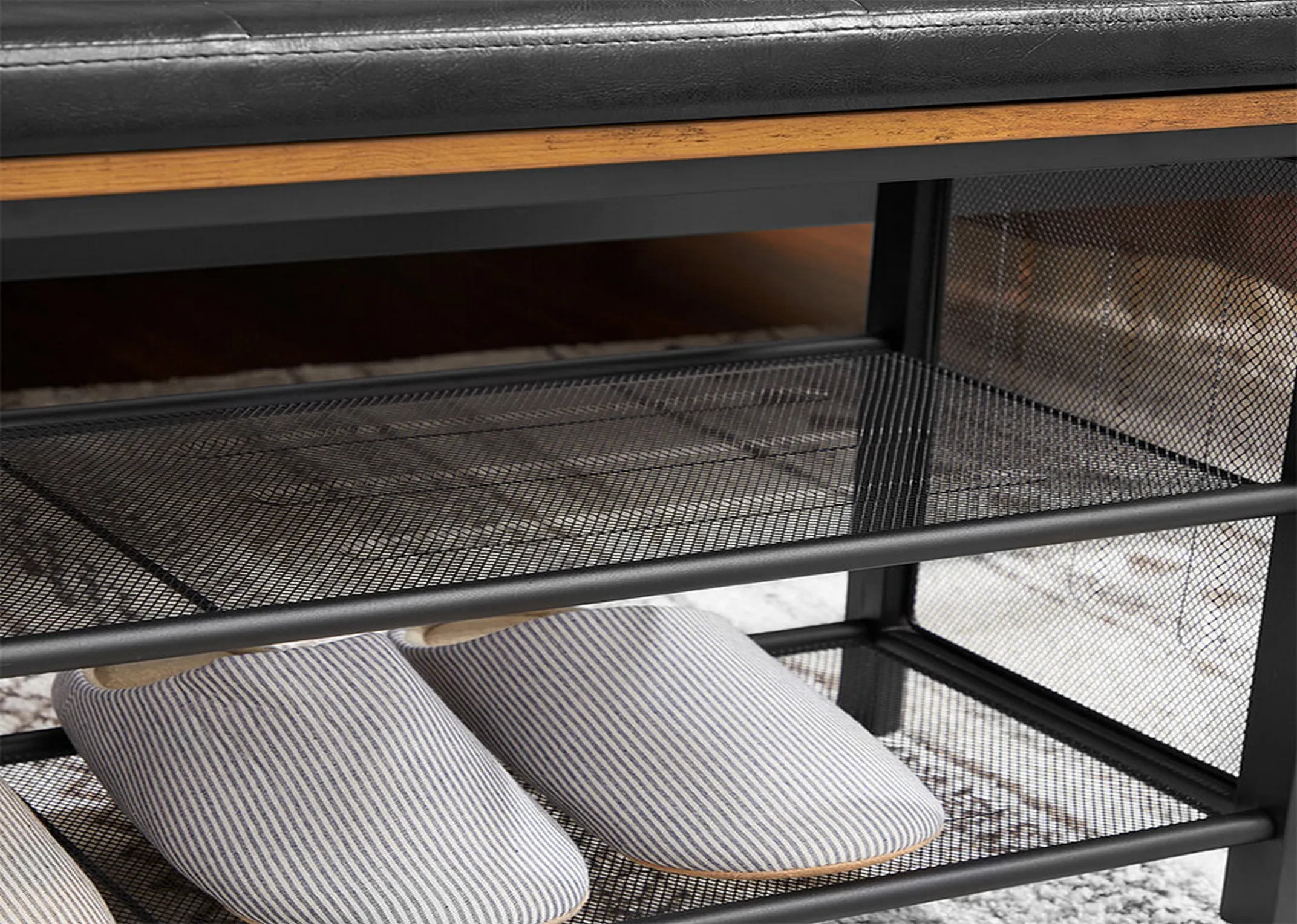 A 2 shelf metal show bench with black faux leather & wood seat from EZ Livings Taos range. Closeup of slippers on lower shelf