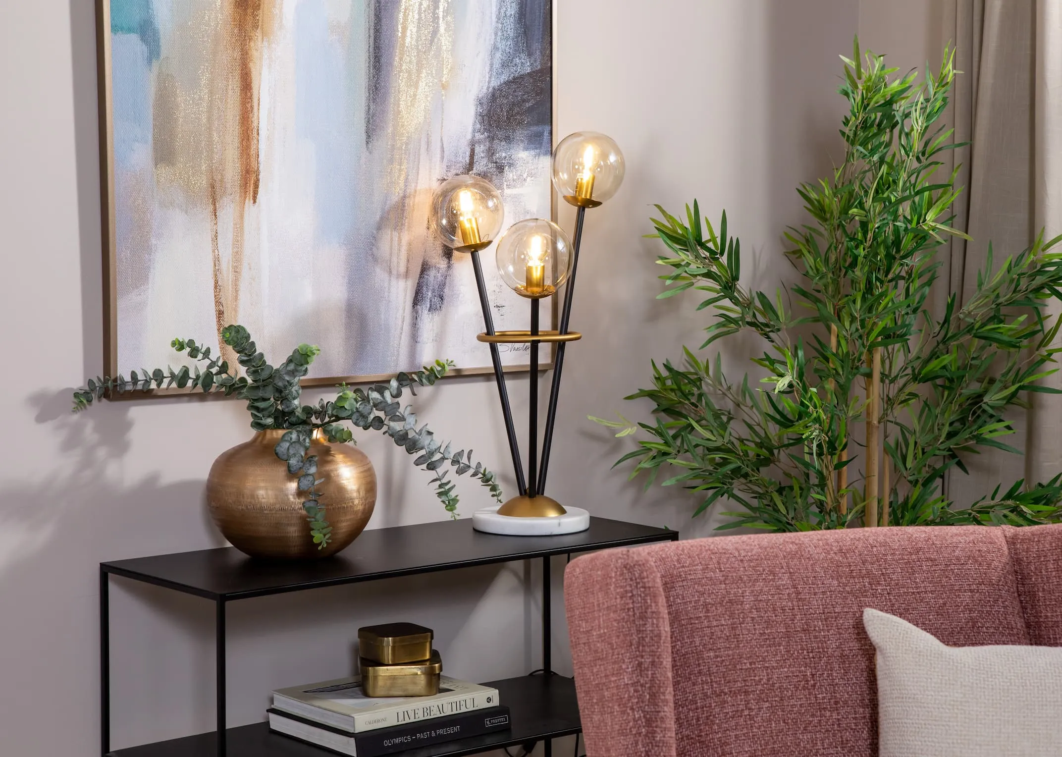 A metal table lamp with 3 round bulbs from EZ Livings Ortez range. Closeup of gold lampholder