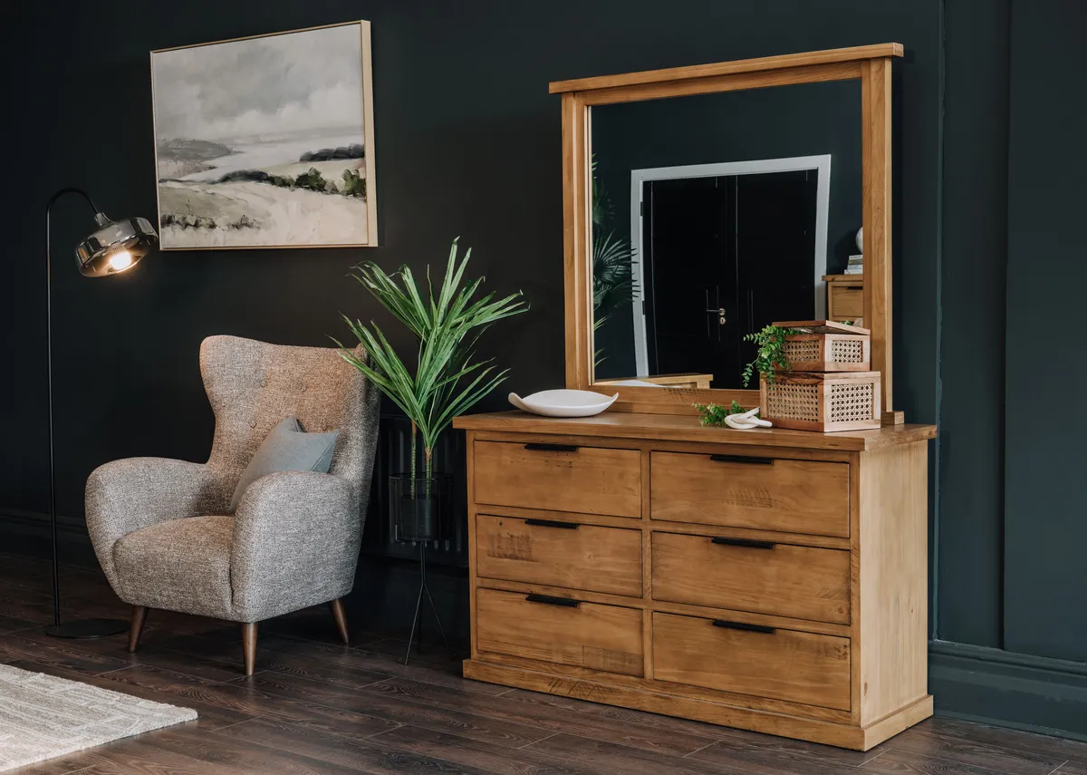 A lifetsyle image of the Pine Creek dresser with Bronx chair and Carter planter.