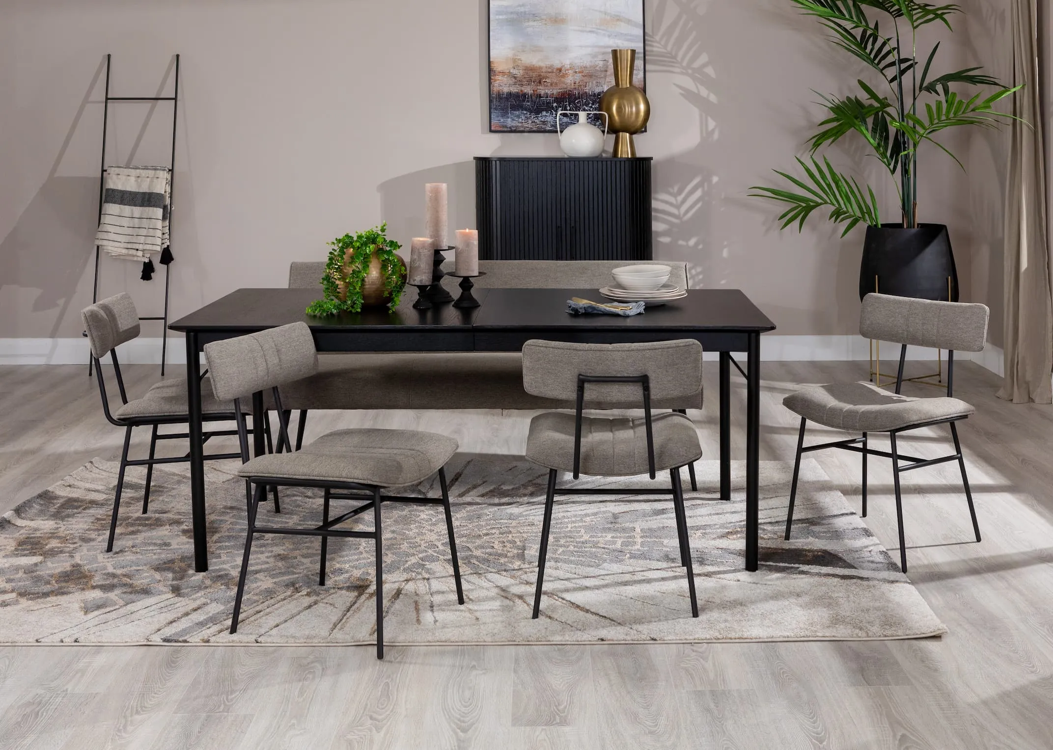 A lifestyle image of the Savona rectangular table with Decker grey fabric chairs and pasha rug with nola cabinet.
