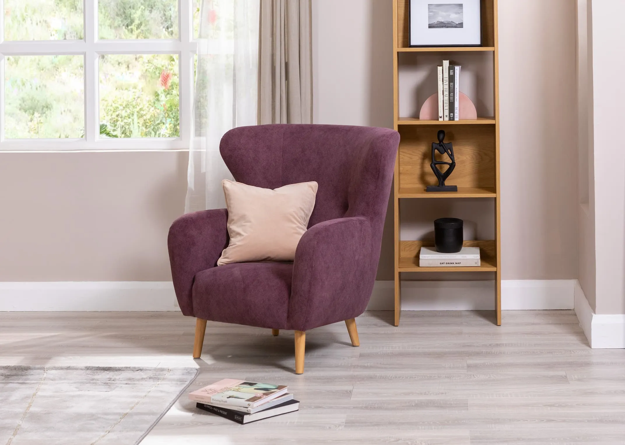 A lifestyle image of the Narnia Armchair with cream cushion and Berkley bookcase