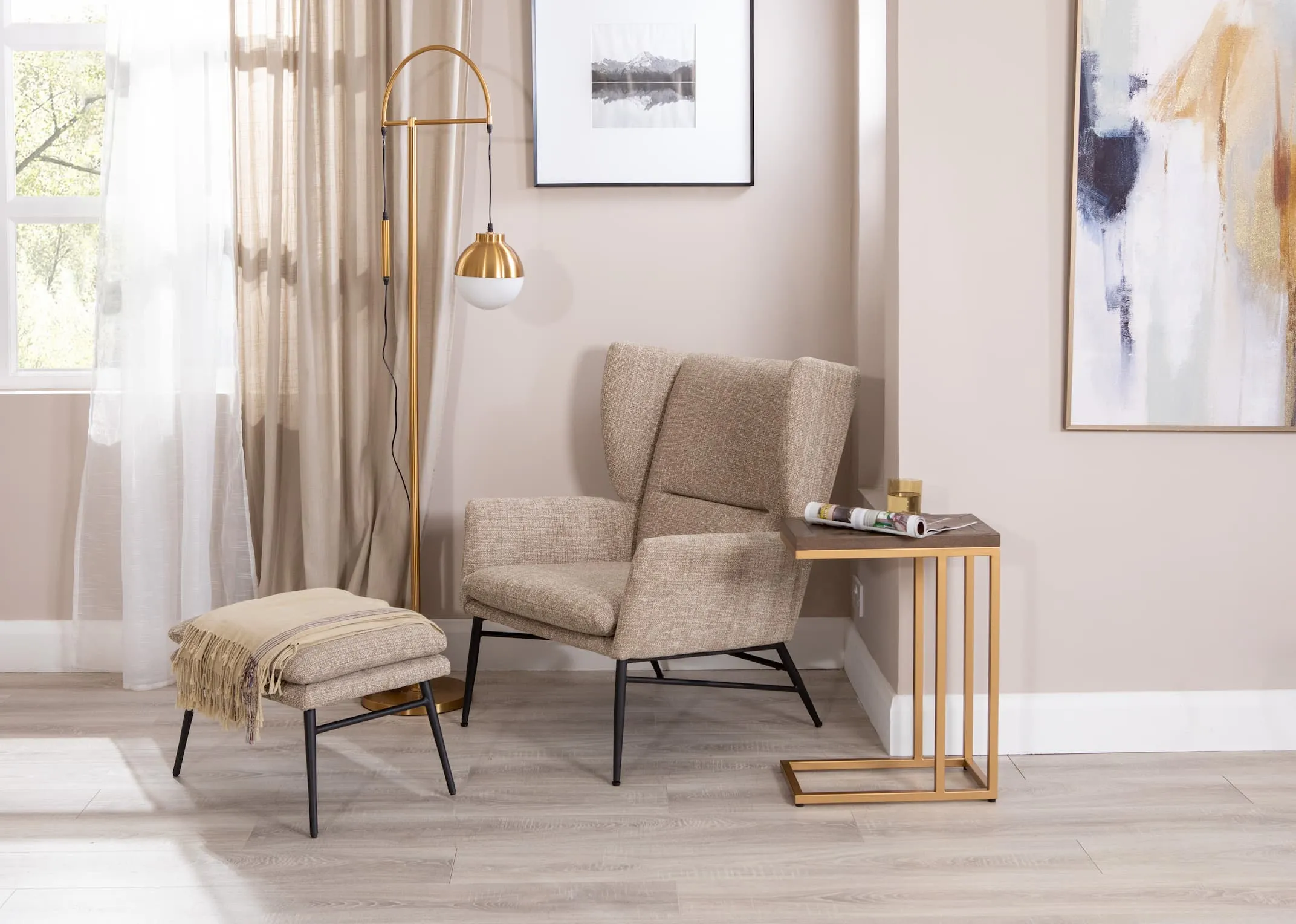 A lifestyle image of the Boston Armchair with footstool in beige with Greenwich sofa table and casper floor lamp