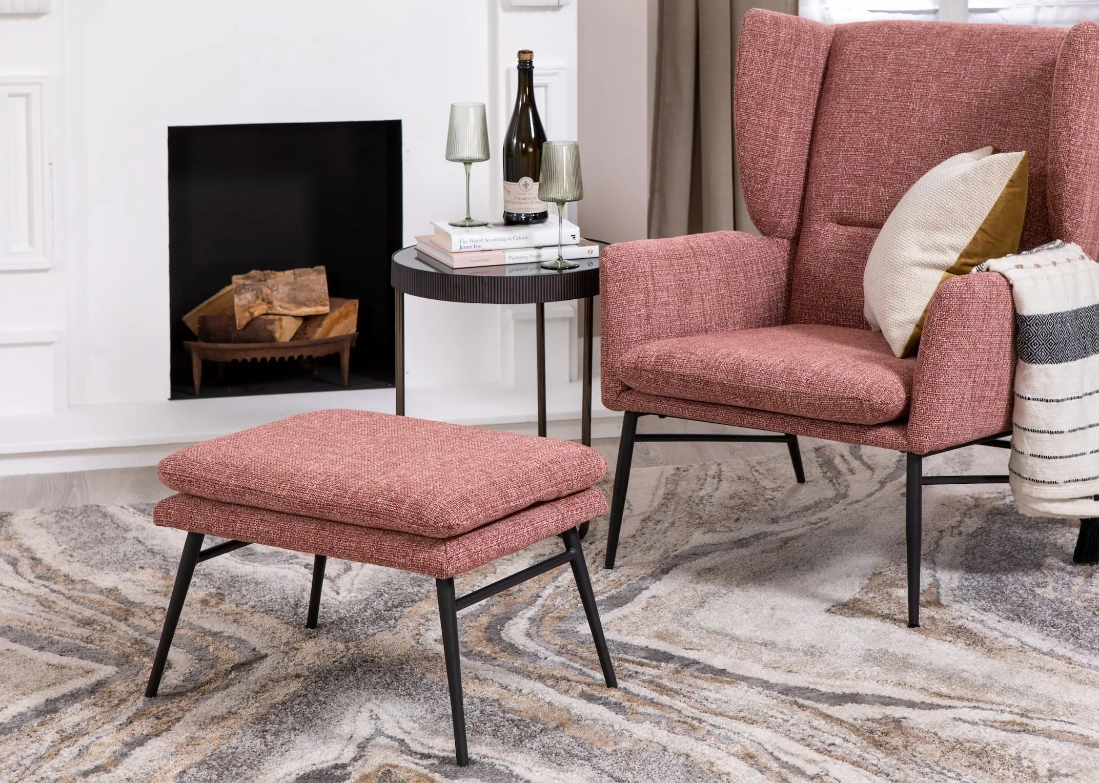 A lifestyle image of the Boston pink chair & footstool with Aruba rug and mandy side table