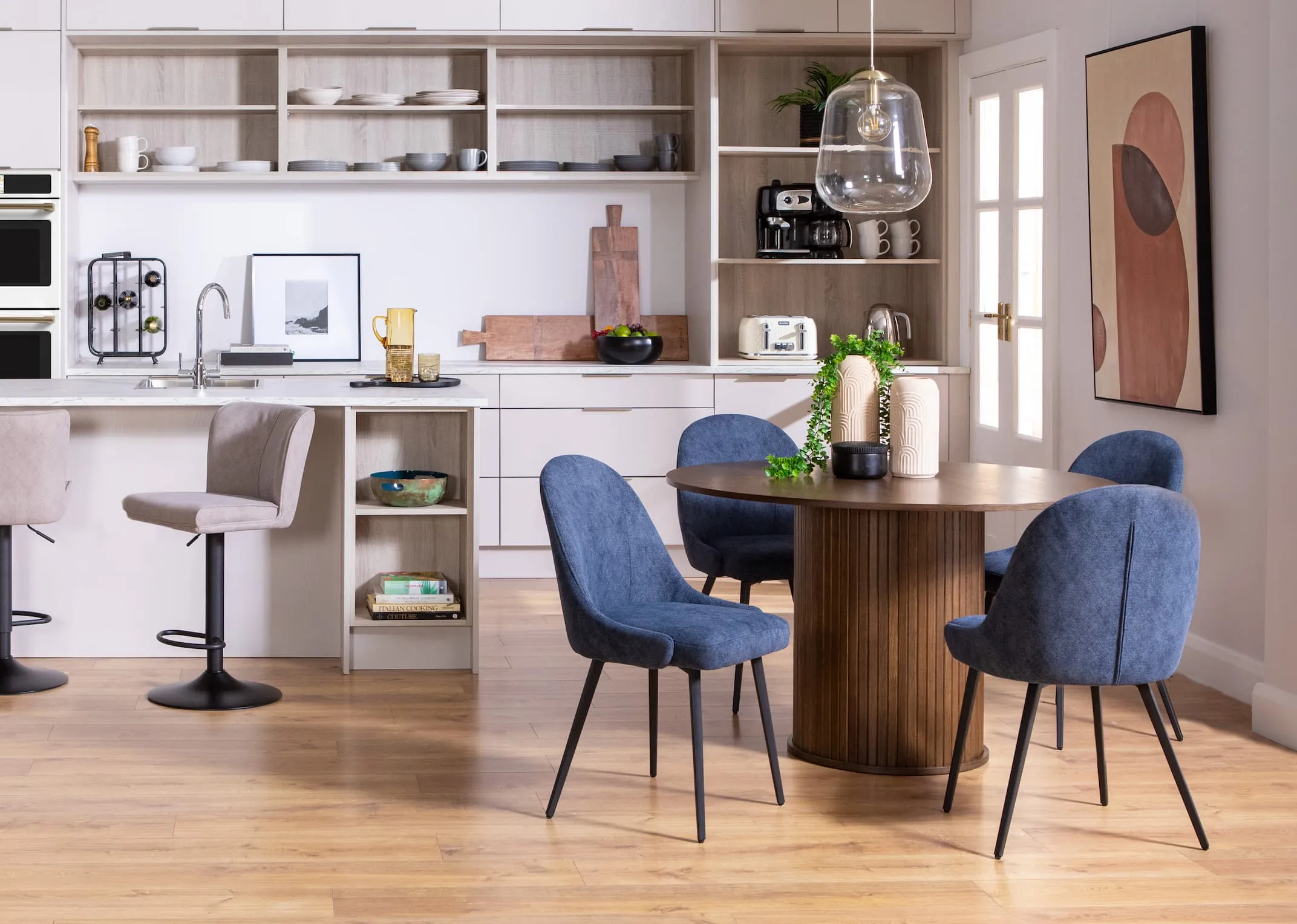 A lifestyle image of the Nola dining table with Jacob blue dining chairs & grey bar stools.