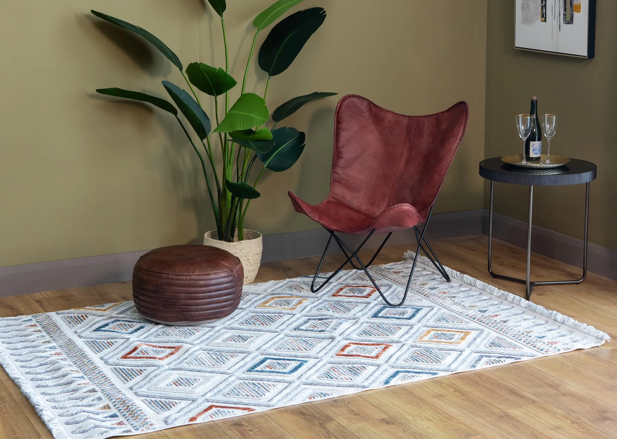 A lifestyle image of the Holiday rug with ranger chair and Claude footstool.
