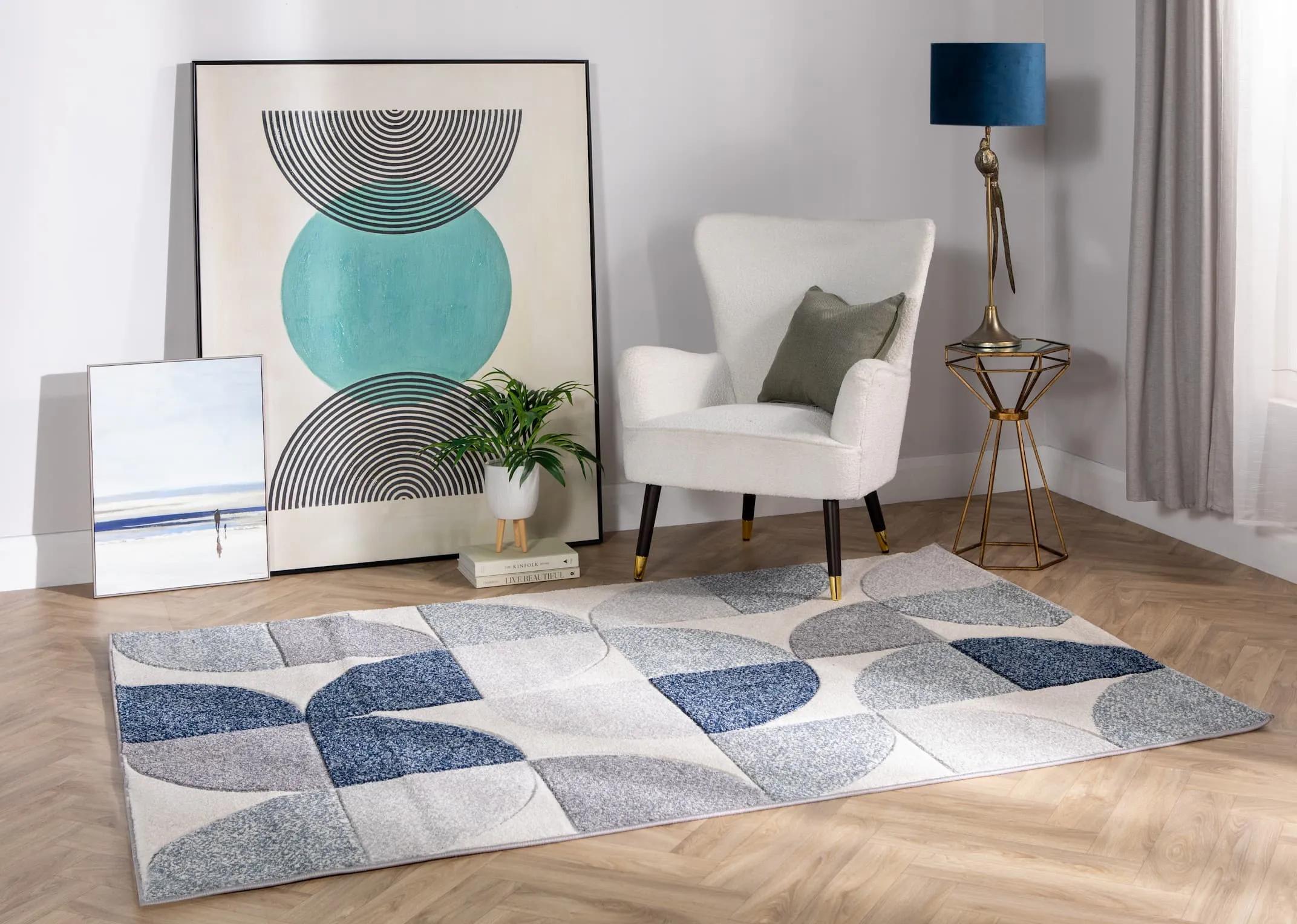 A lifetsyle image of the Holden blue rug with the Shiraz chair and hourglass side table.
