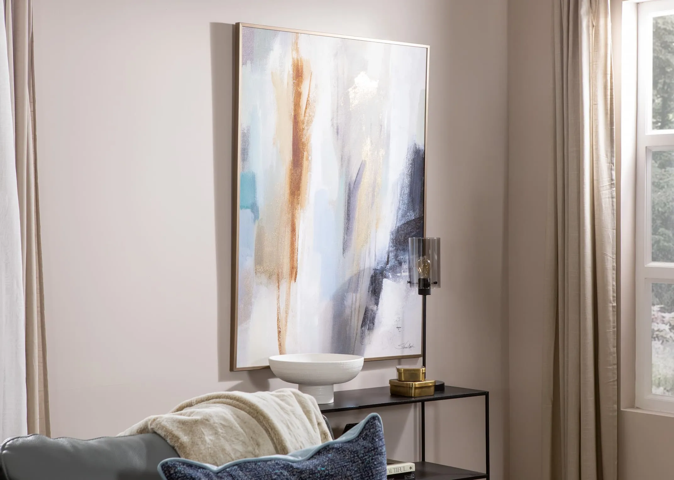 A gold framed canvas with blue and brown and white strokes of colors from EZ Livings Inspired range. Clsoeup
