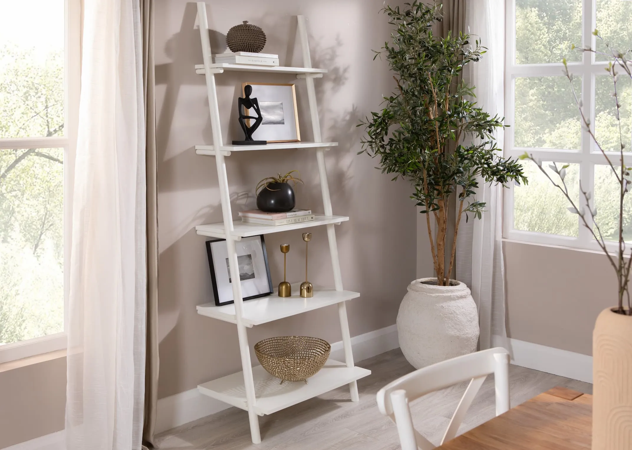A lifestyle image of the Step small bookcase with a selection of EZ Livings candle holders & home decor with Olive plant.