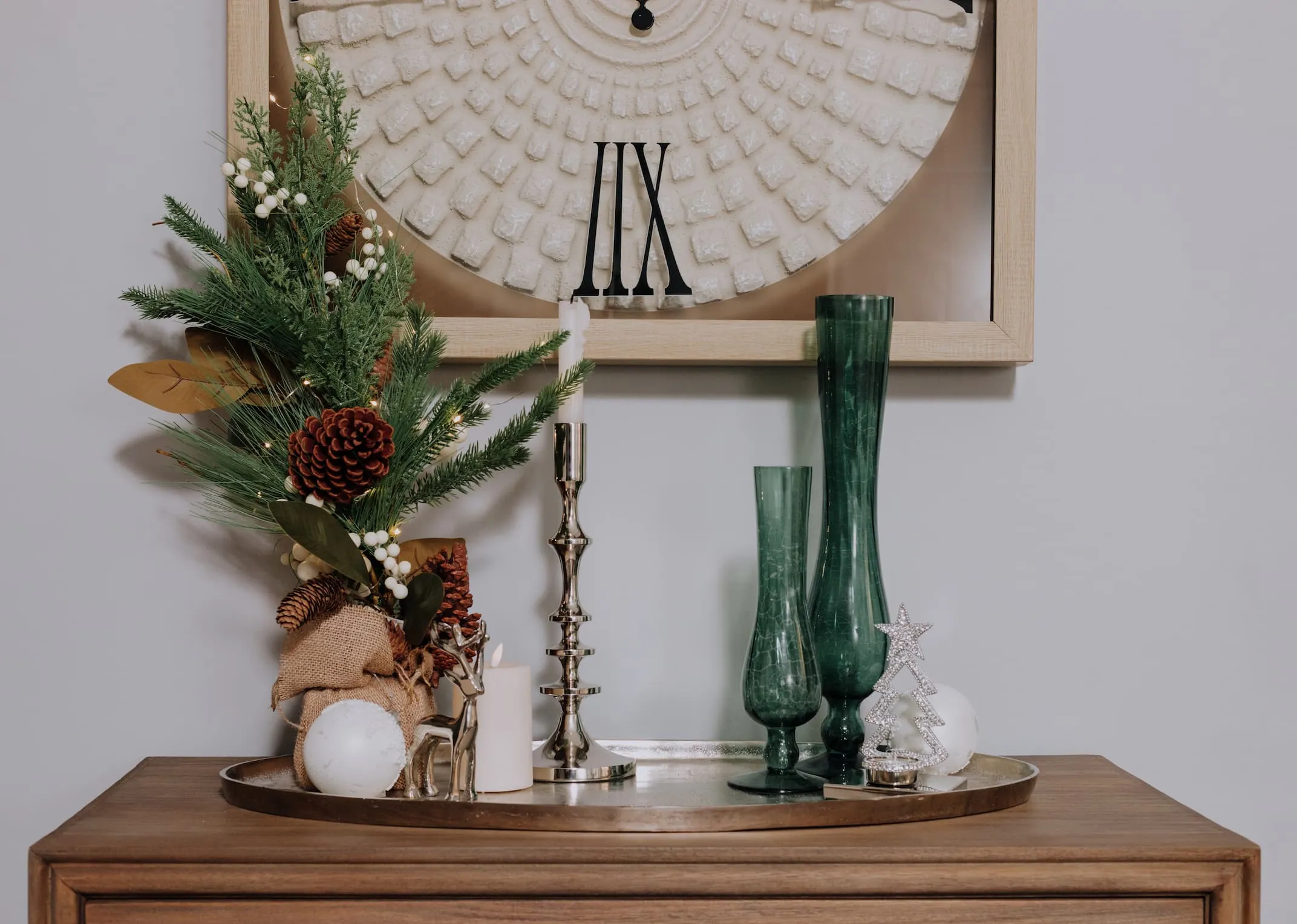 A lifetsyle image of the Pearl & Pine tree on a sideboard with Silver candlestick and white baubles.