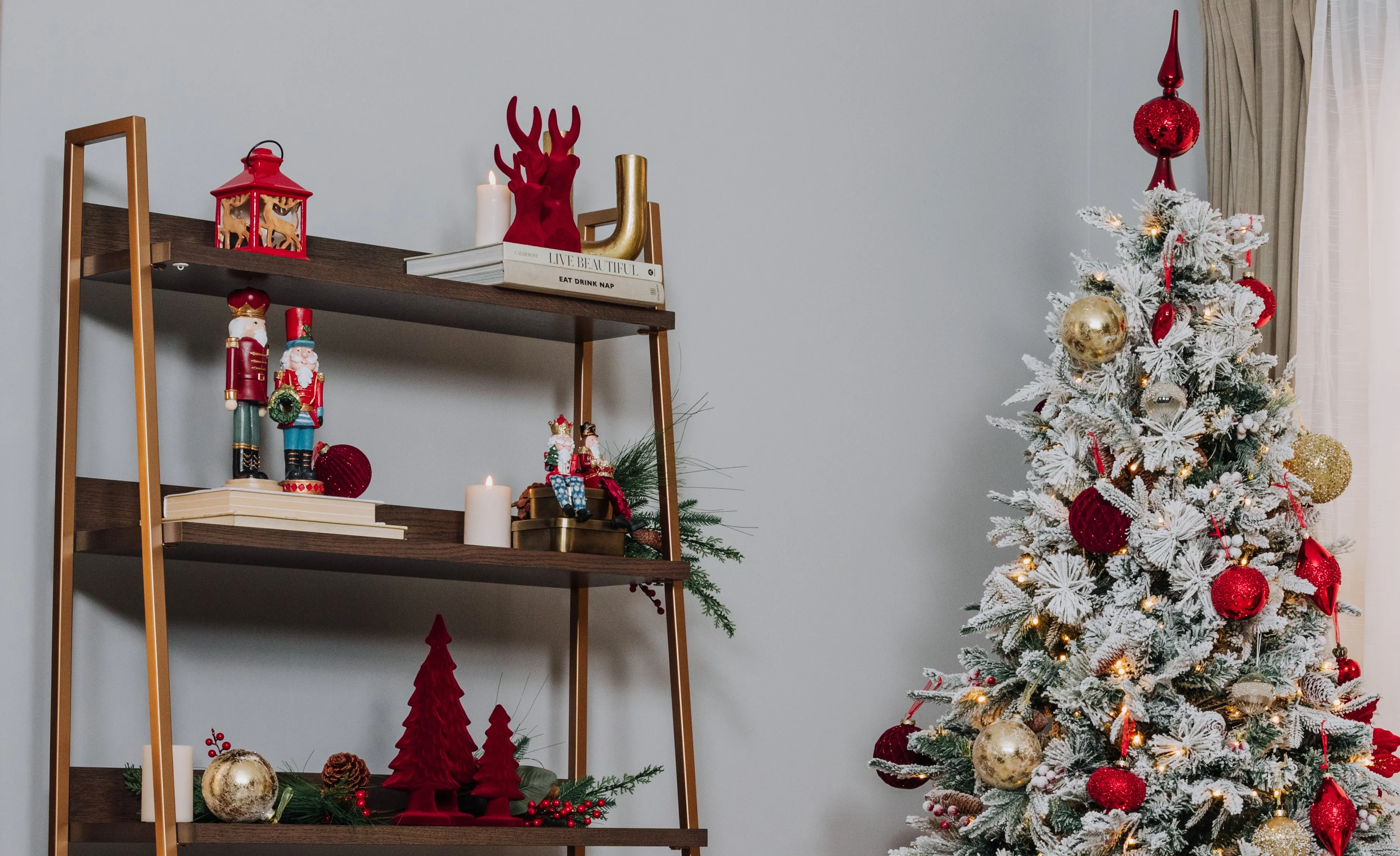 A lifestyle image of the Greenwich bookcase with red tree ornaments and Nutcracker with tree & Vermont snow tree.