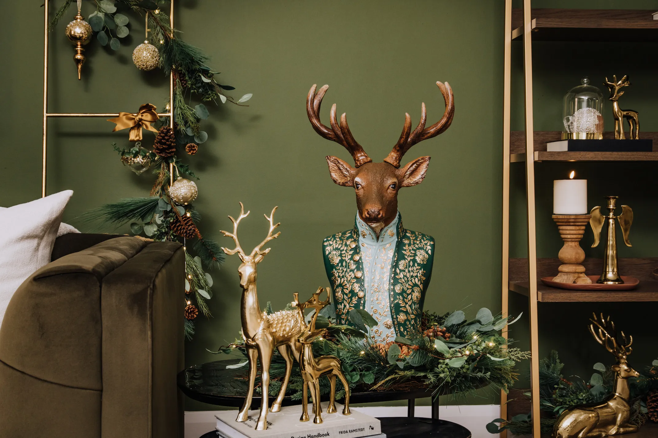 A lifestyle image of the Regal Stag Ornament with a range of Gold deer ornaments & Wooden trees.