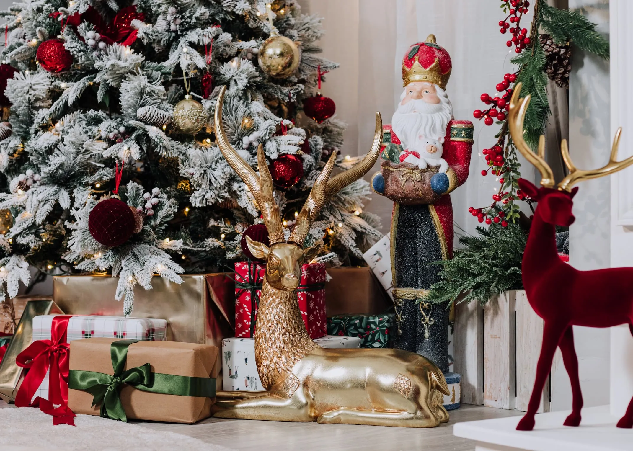 A lifestyle image of the Vermont snow tree with lying deer and Santa Nutcracker and Red Standing Deer.