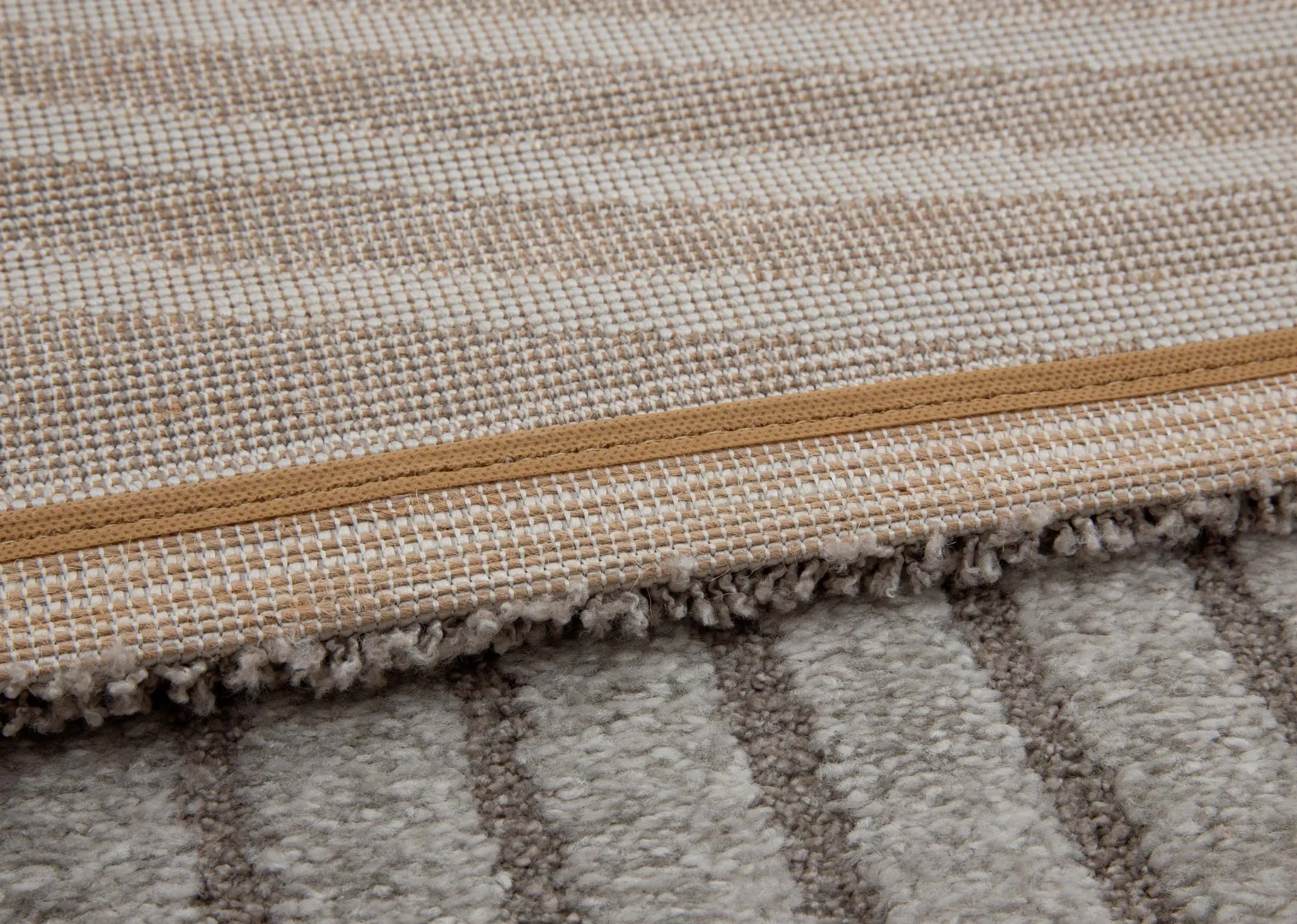 A grey geometric large rug from EZ Livings Eli range. Closeup of underlay