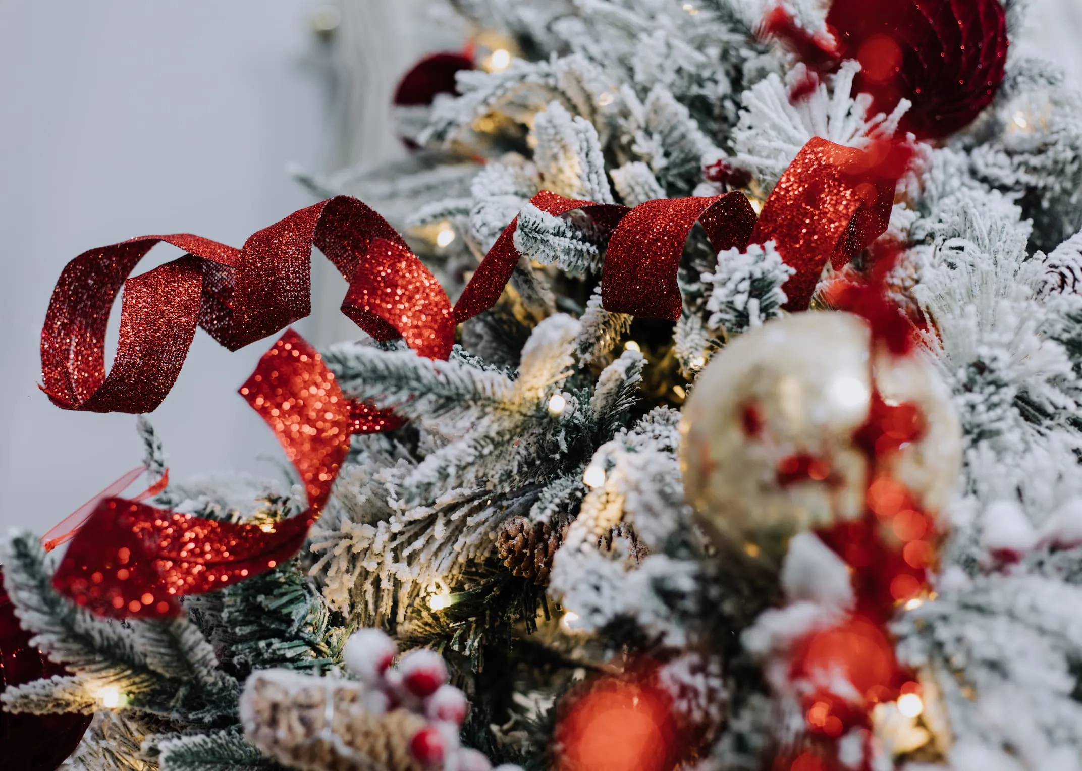 A lifestyle image of the red curl glitter spray on a Vermont snow tree.