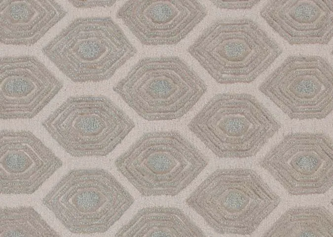 A beige honeycomb print rug from EZ Livings Elio range. Closeup of hot of green.