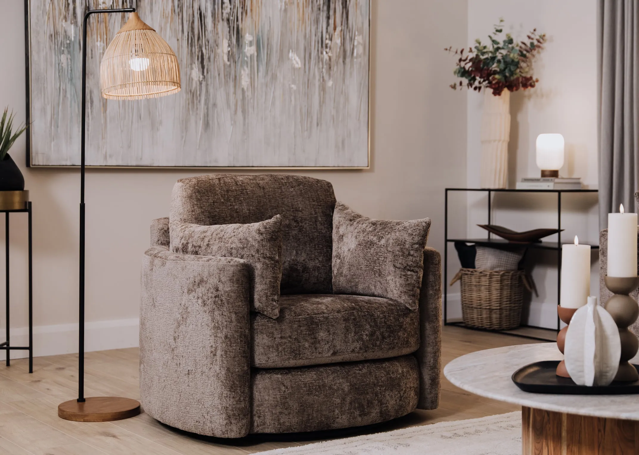 A lifestyle image of the Naples swivel armchair with the Pebble Console and the coco floor lamp.