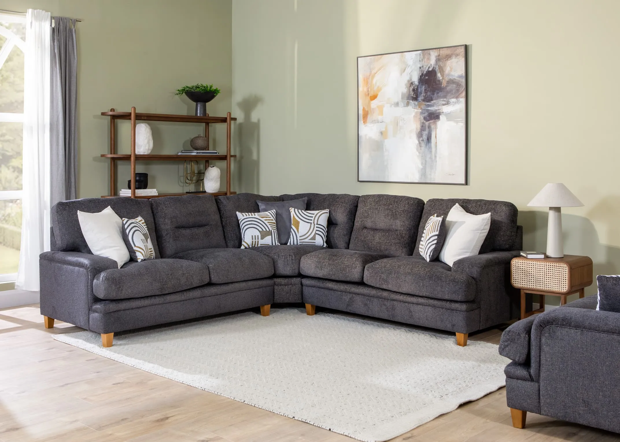 A lifestyle image of the Trieste Corner sofa with retro bookcase and may locker from EZ Living.