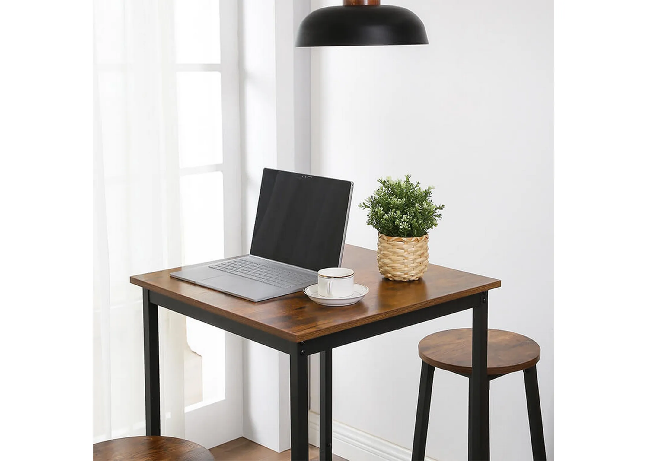A lifestyle image of the Bourbon square bar table with laptop and plants in use as a desk with 2 stools