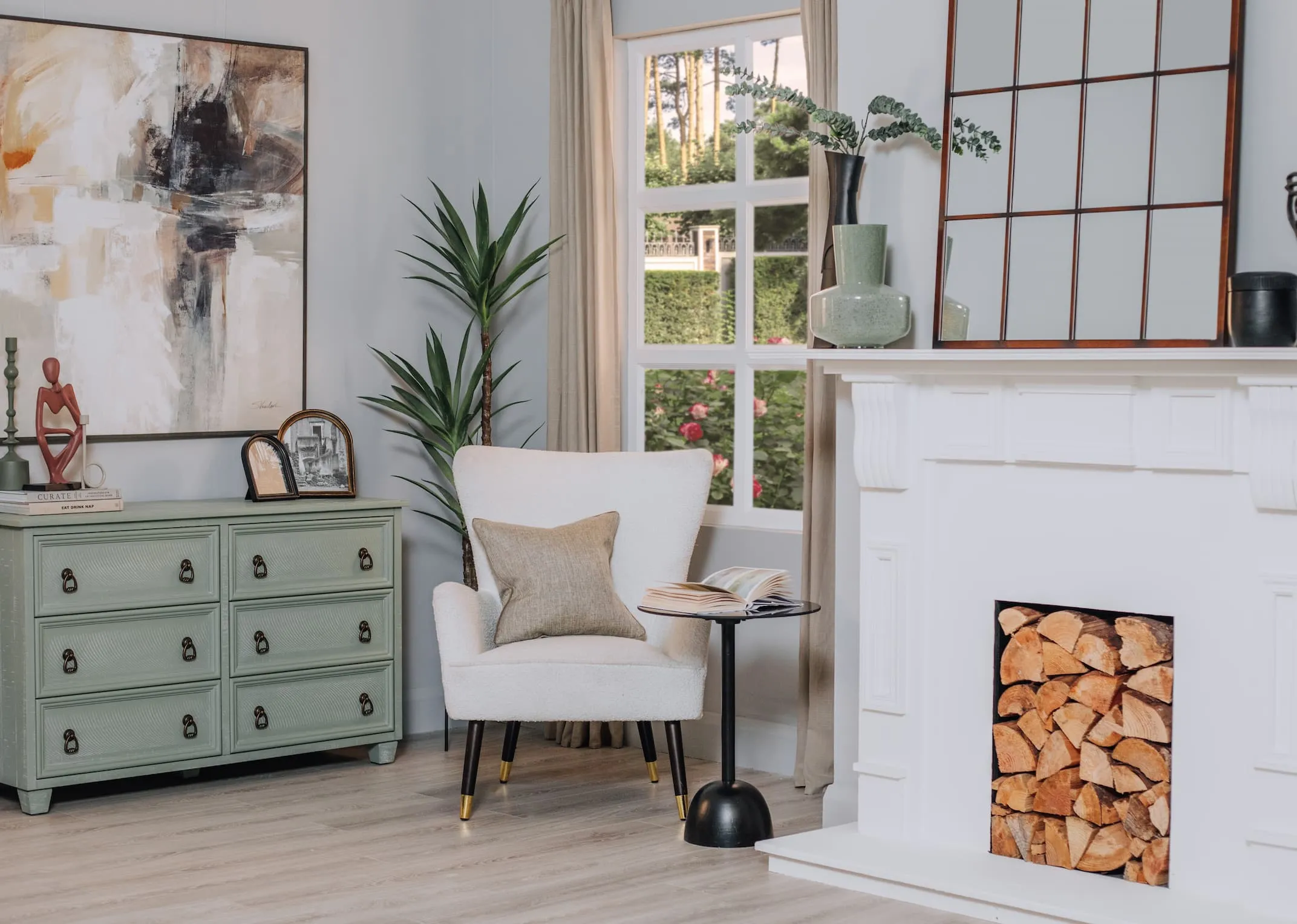A lifestyle image of the Grenoble green chest with Terracotta deco ornament and a selection of photoframes beside Shiraz chair.