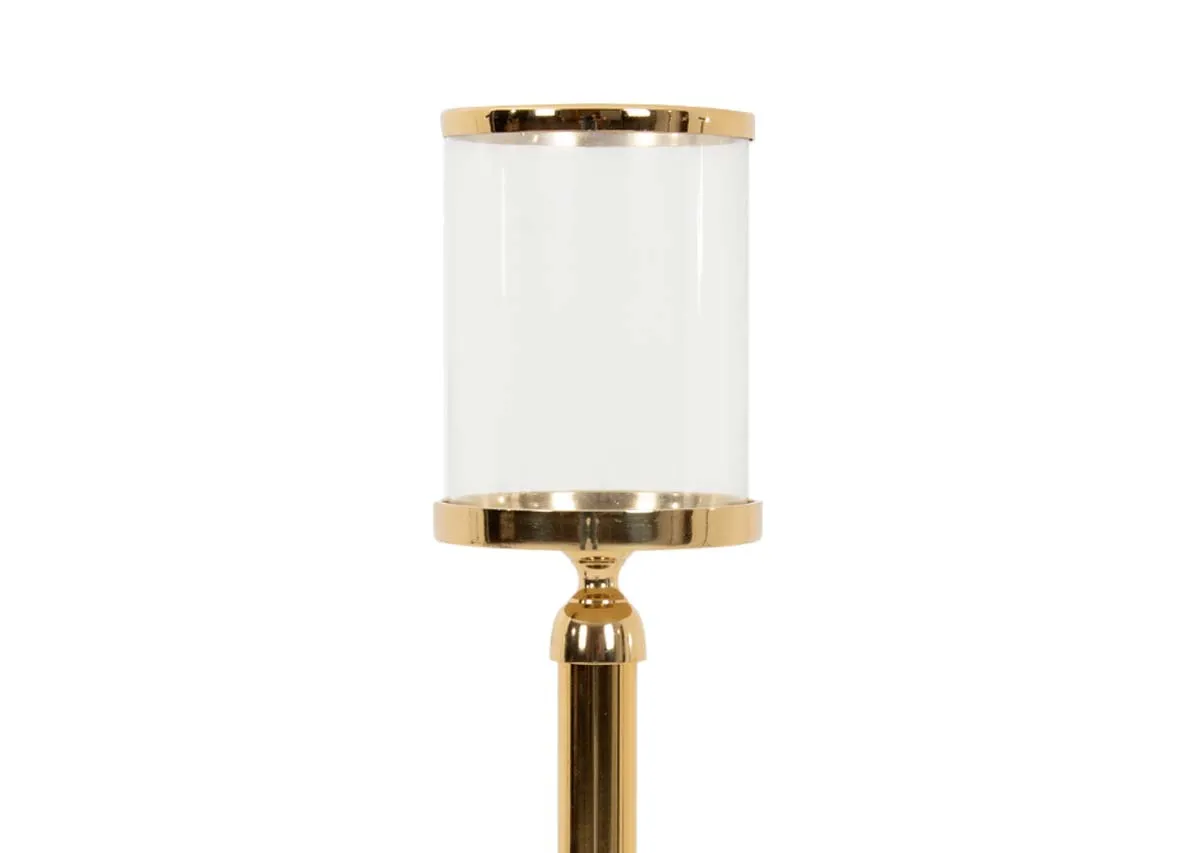 A gold stand with glass pillar candle holder from EZ Livings Christmas range.Closeup of gold trim on candleholder.