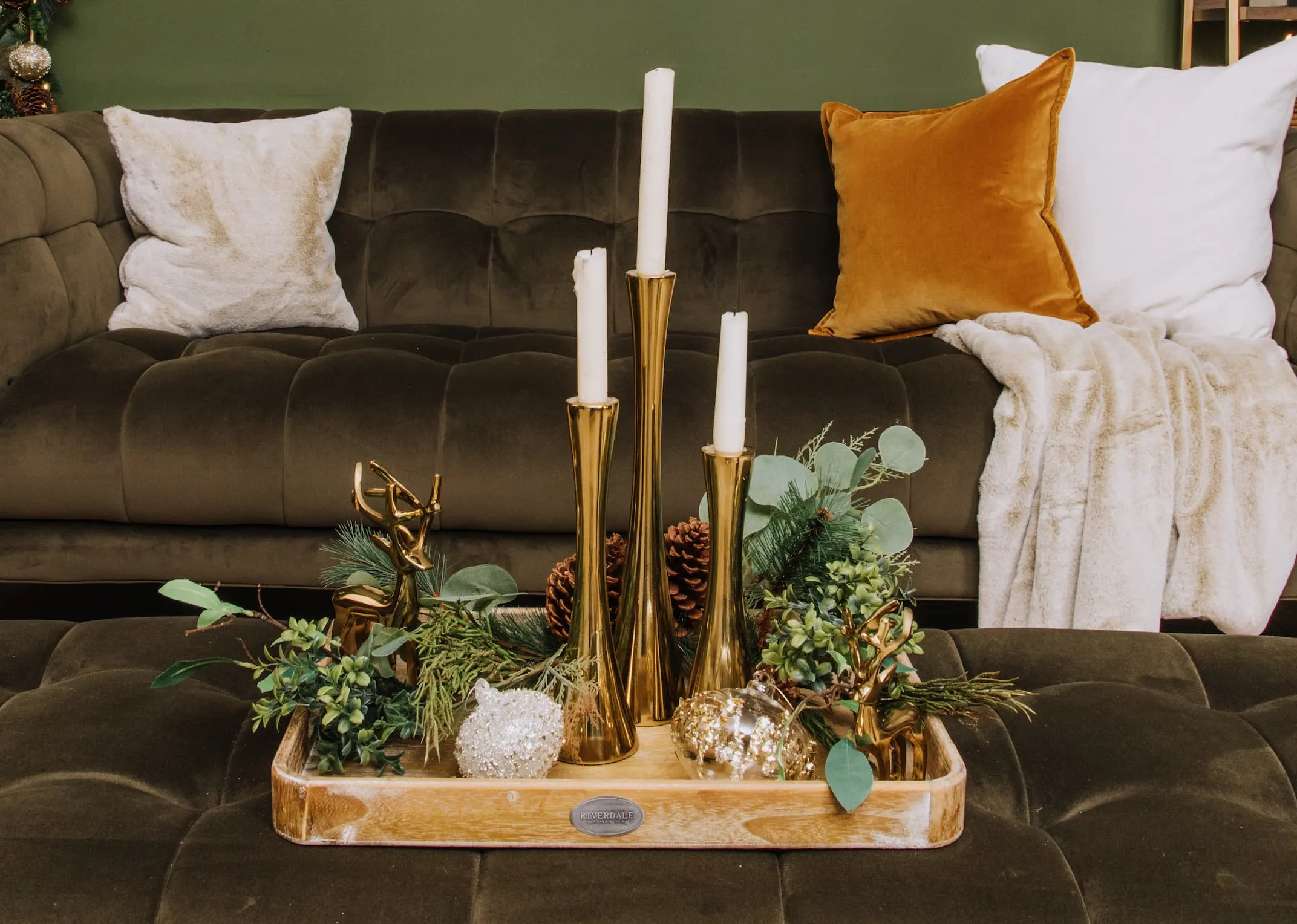 A lifestyle image of the Gold Candle Holders on a wooden tray.