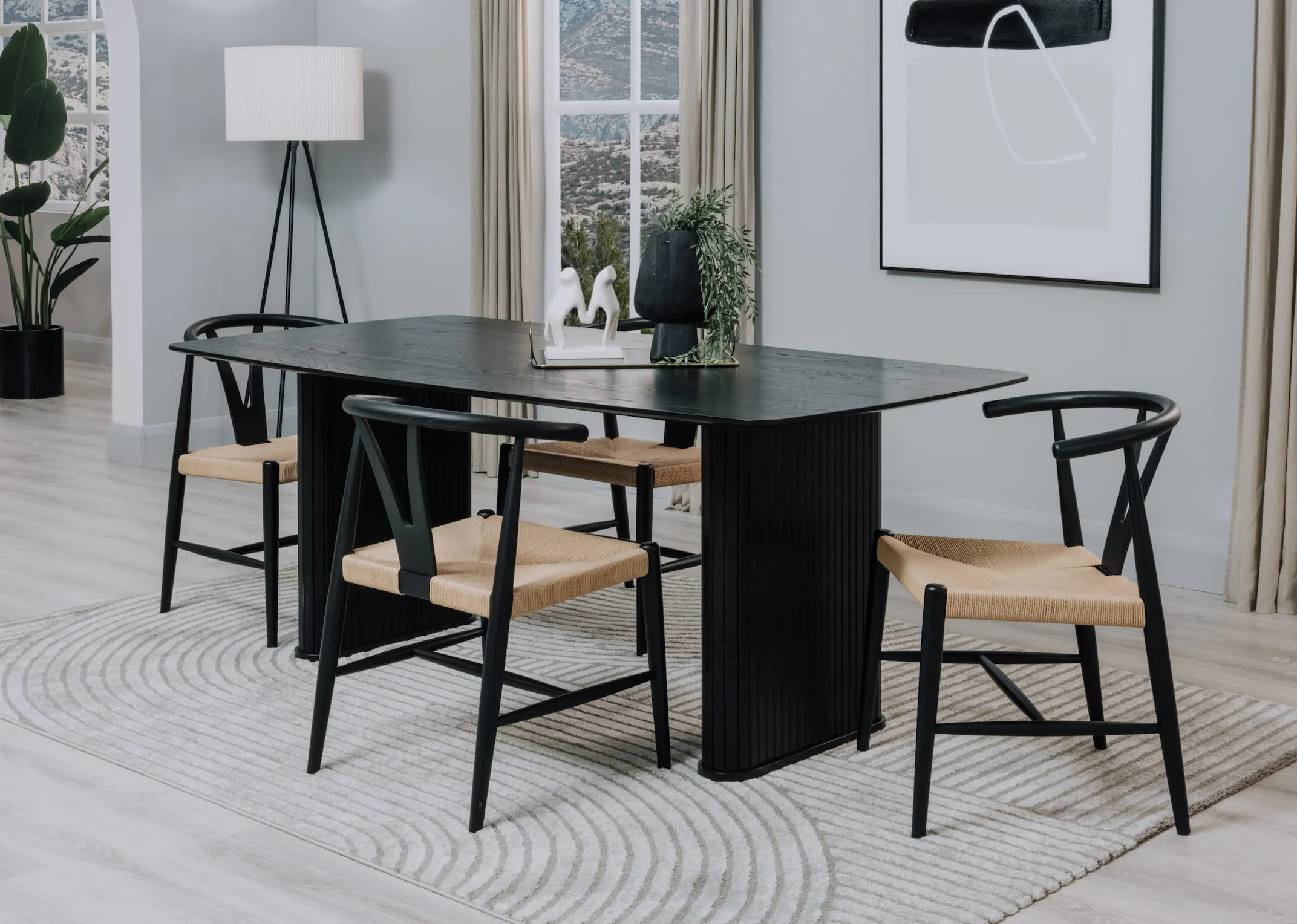 A lifestyle image of the Nola black table with Cape chairs and Eli rug from EZ Livings range.