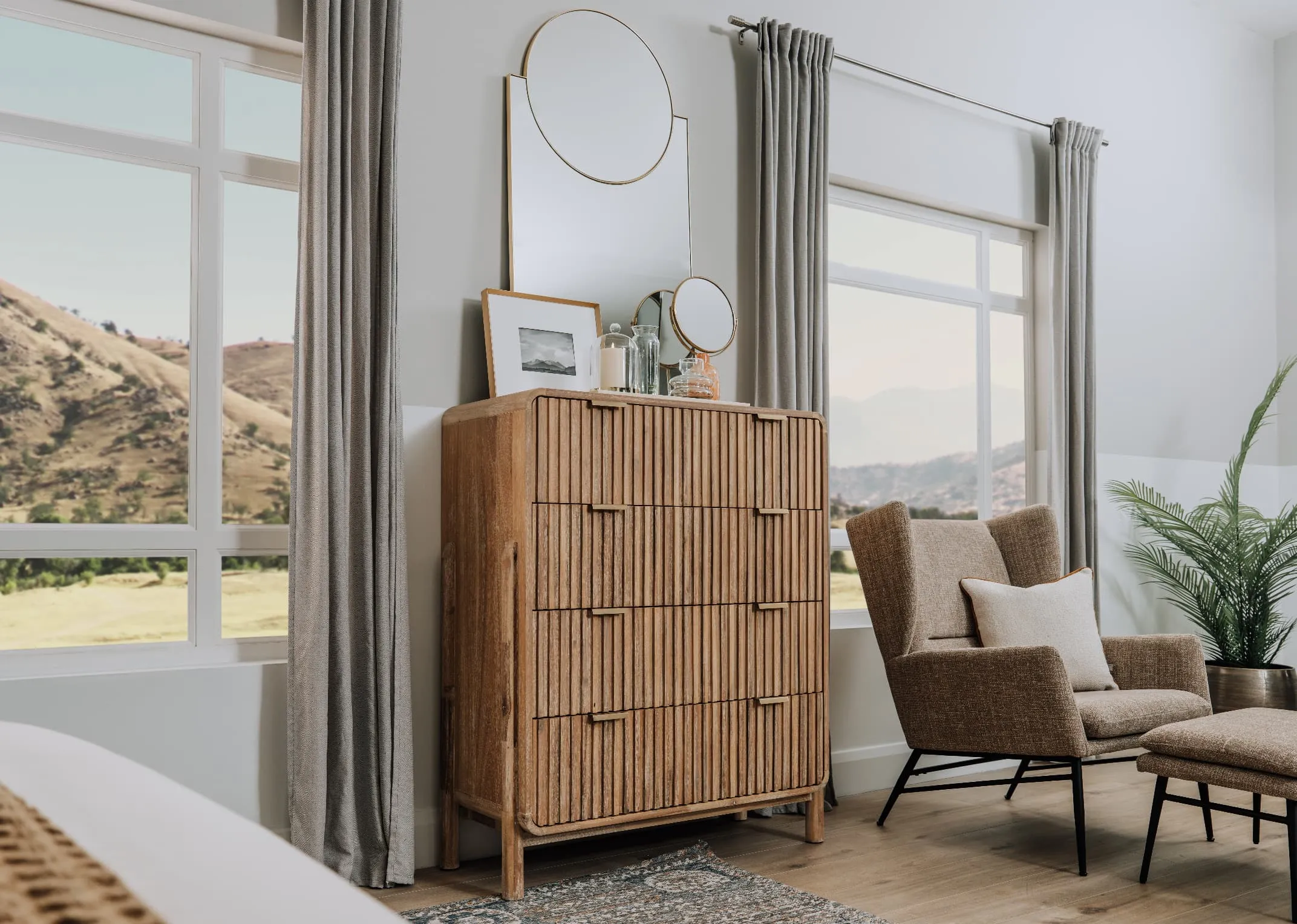 A lifestyle image of the Milo dresser with Calista mirror & Boston occasional chair & footstool.