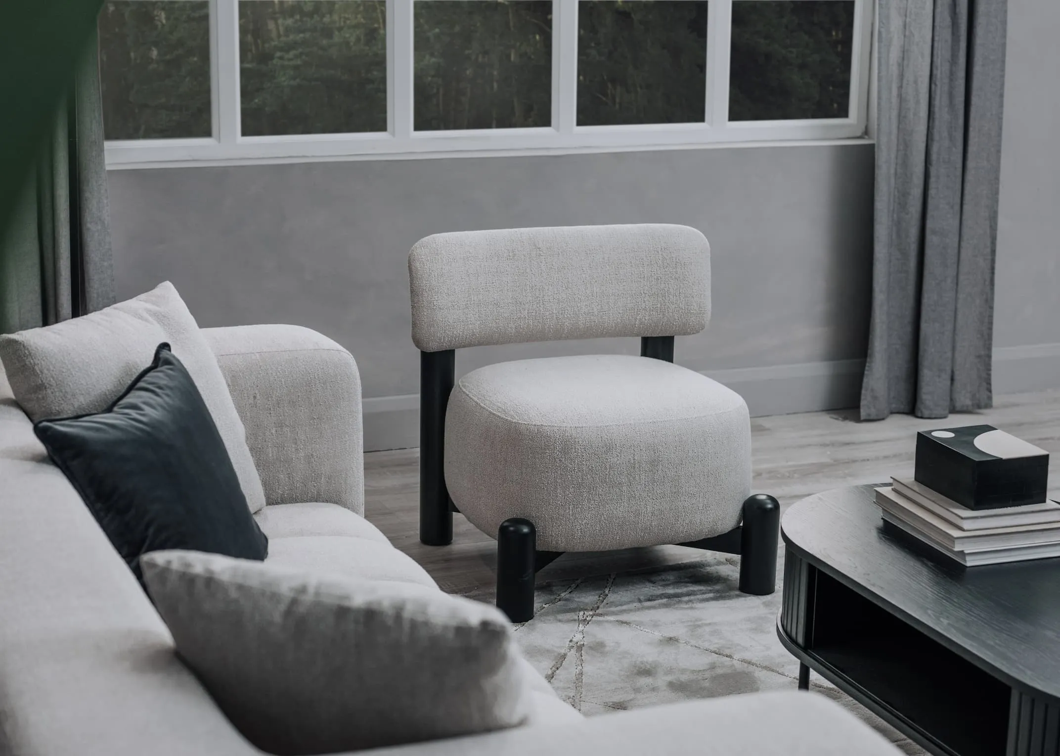 A lifestyle image of the Emebr chair with Brandon sofa and Nola coffee table.